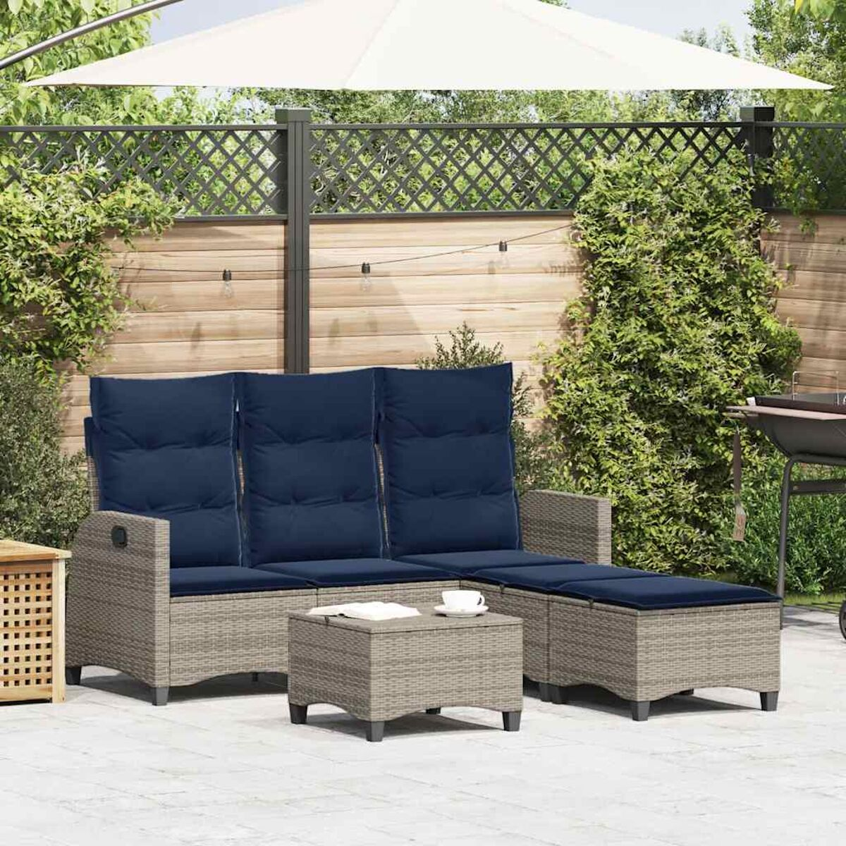 Set di divani in vimini da esterno con cuscini blu e tavolino con set da tè.