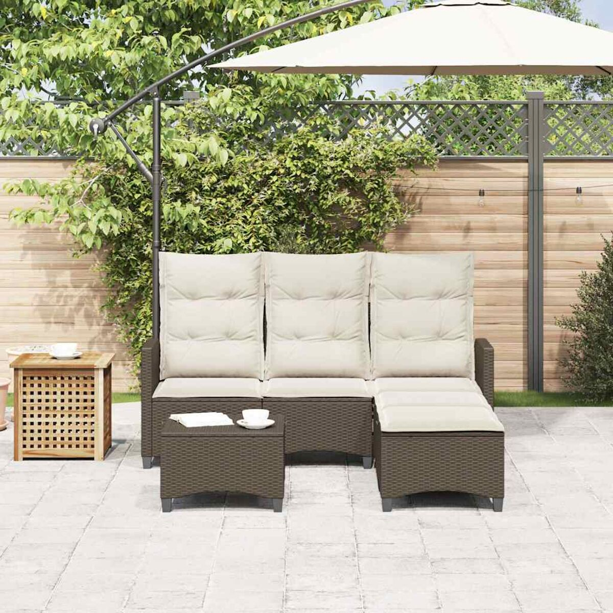 Set patio esterno con divano, due tavoli e ombrellone. Cuscini beige e pavimento in pietra.