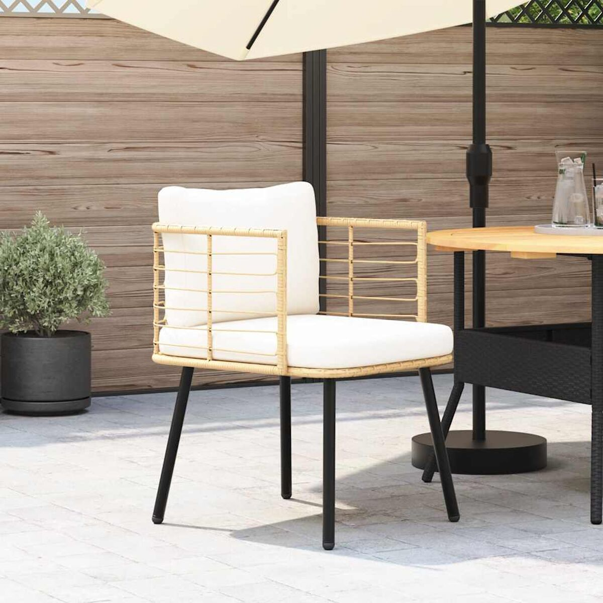 Sedia con cuscino bianco e gambe nere, su un patio con un ombrellone.