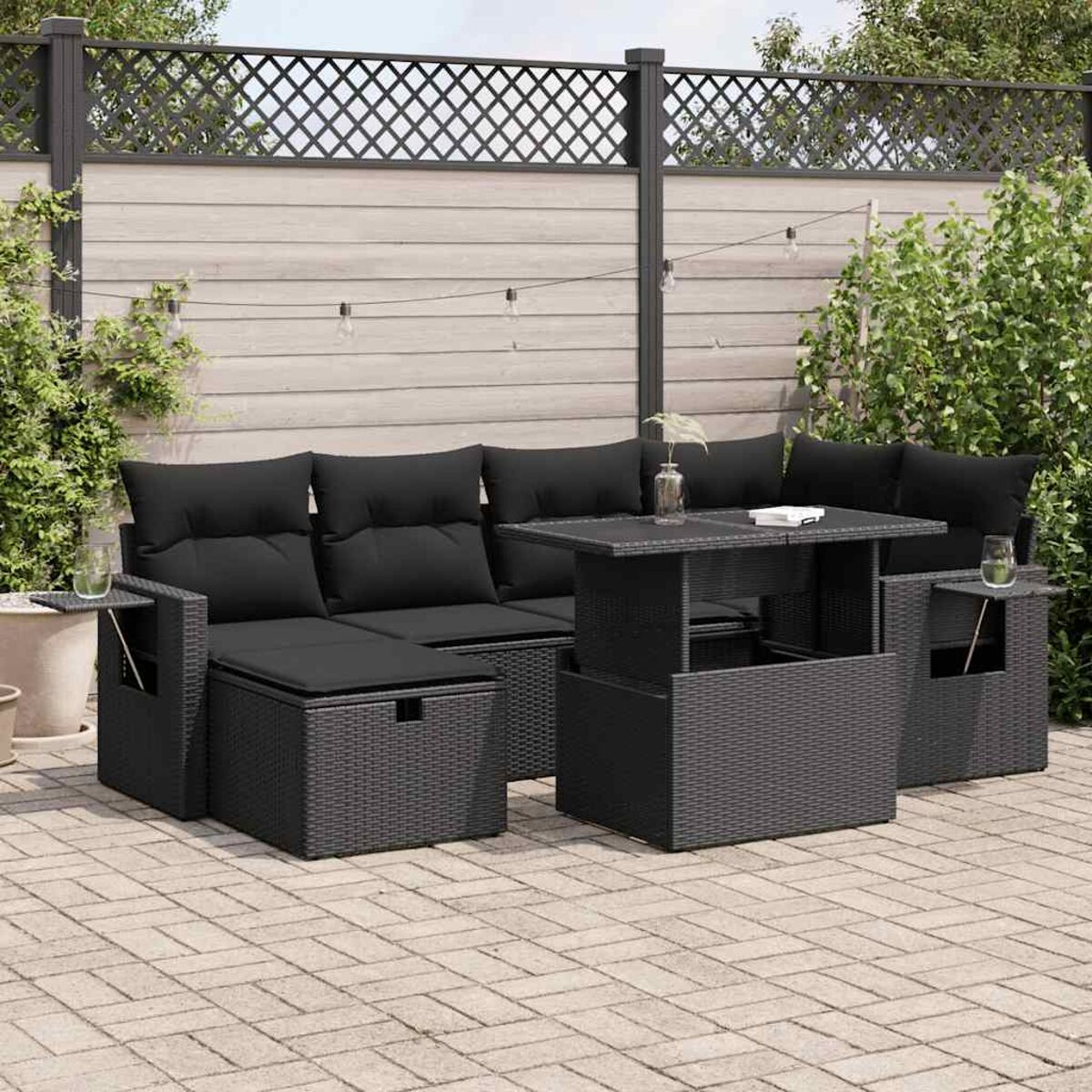 Schwarzes Sitzgruppen-Set für den Außenbereich mit Kissen, einem Tisch und einem Tisch mit Hubplatte.
