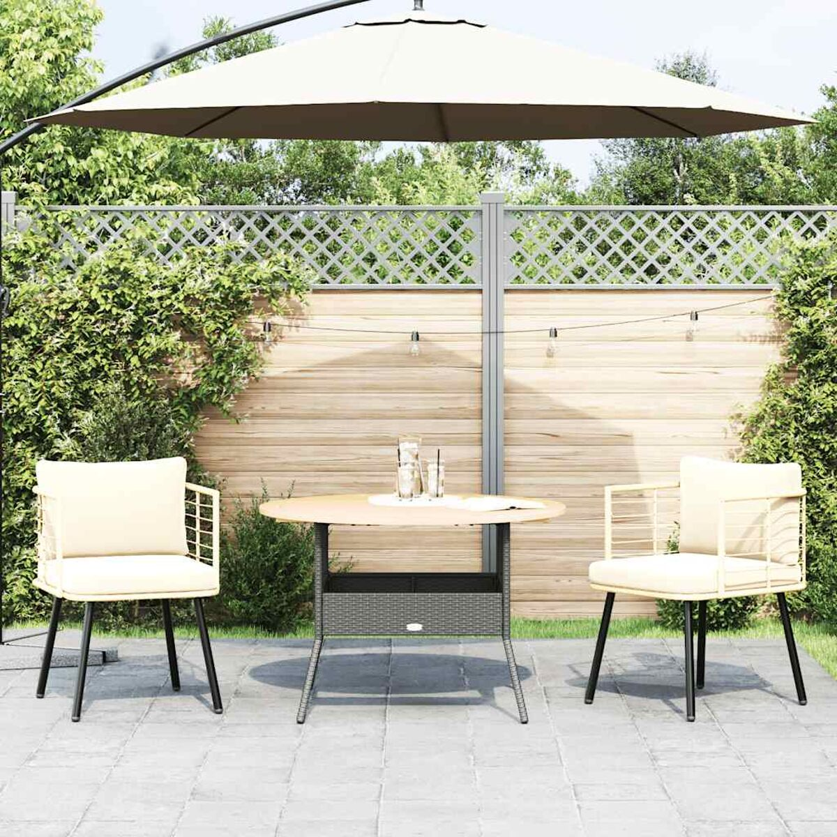 Outdoor-Terrassenset. Runder Tisch, zwei Stühle und ein großer Sonnenschirm. Umzäunter Hintergrund.