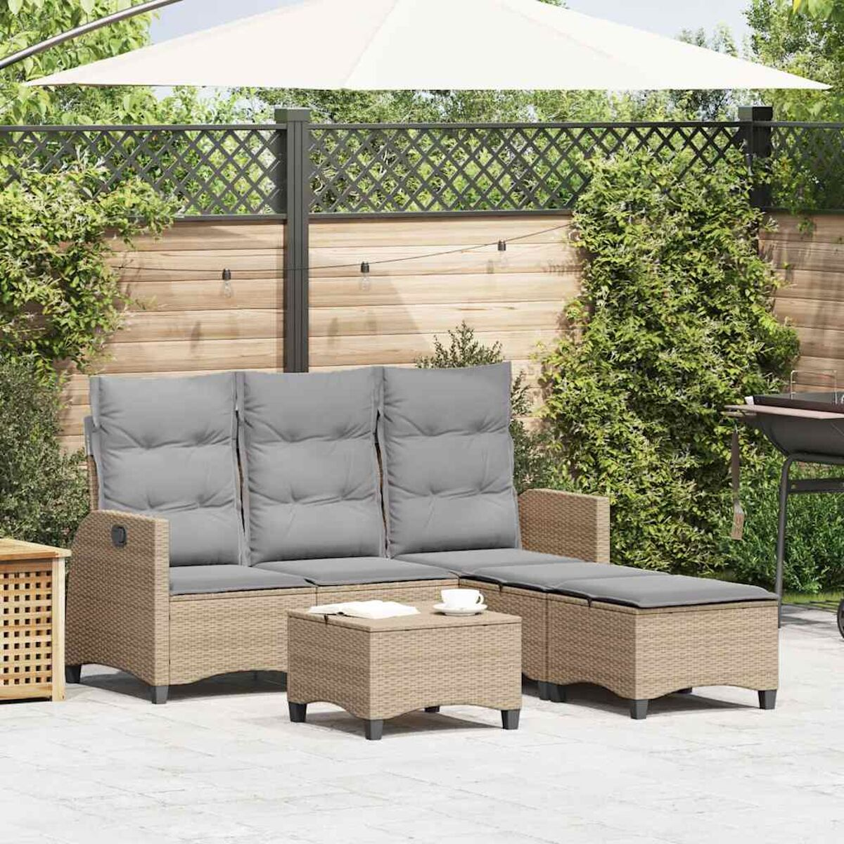 Set da patio con divano, poggiapiedi e tavolo, tutti con cuscini grigi. Ambiente esterno.
