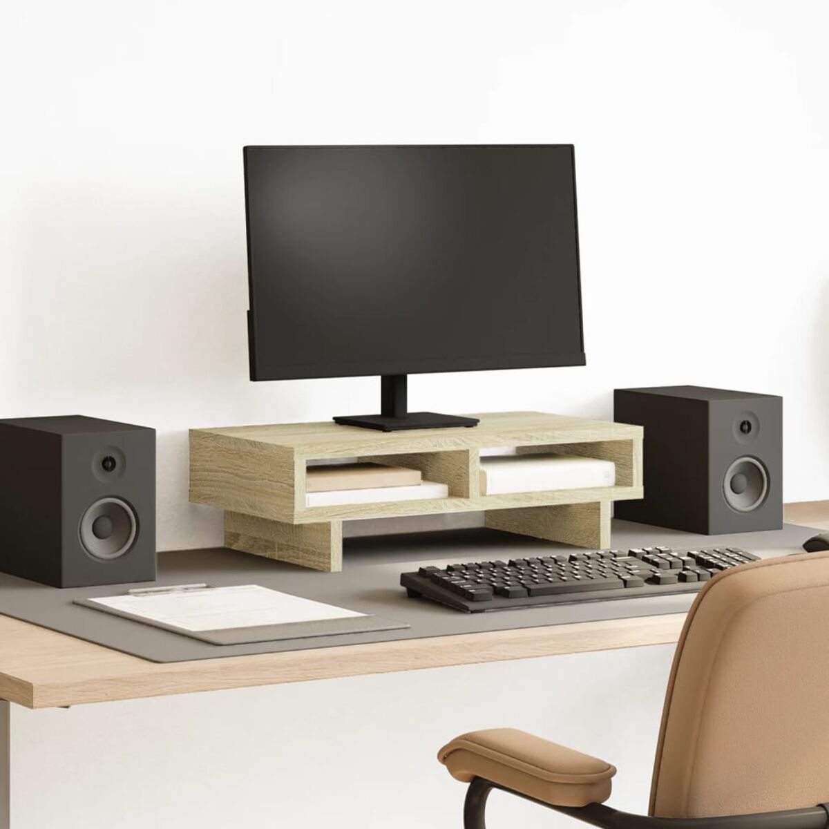Schreibtisch-Setup mit Monitor, Lautsprechern, Tastatur und Mauspad. Es hat einen holzfarbenen Schreibtisch und eine weiße Wand.