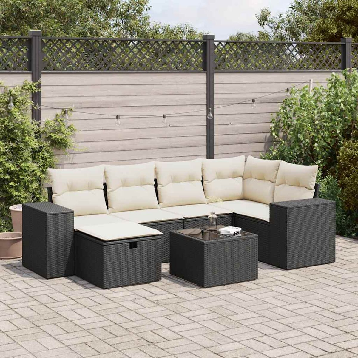Ein modernes Outdoor-Sofa-Set mit Glastisch in einem Garten.