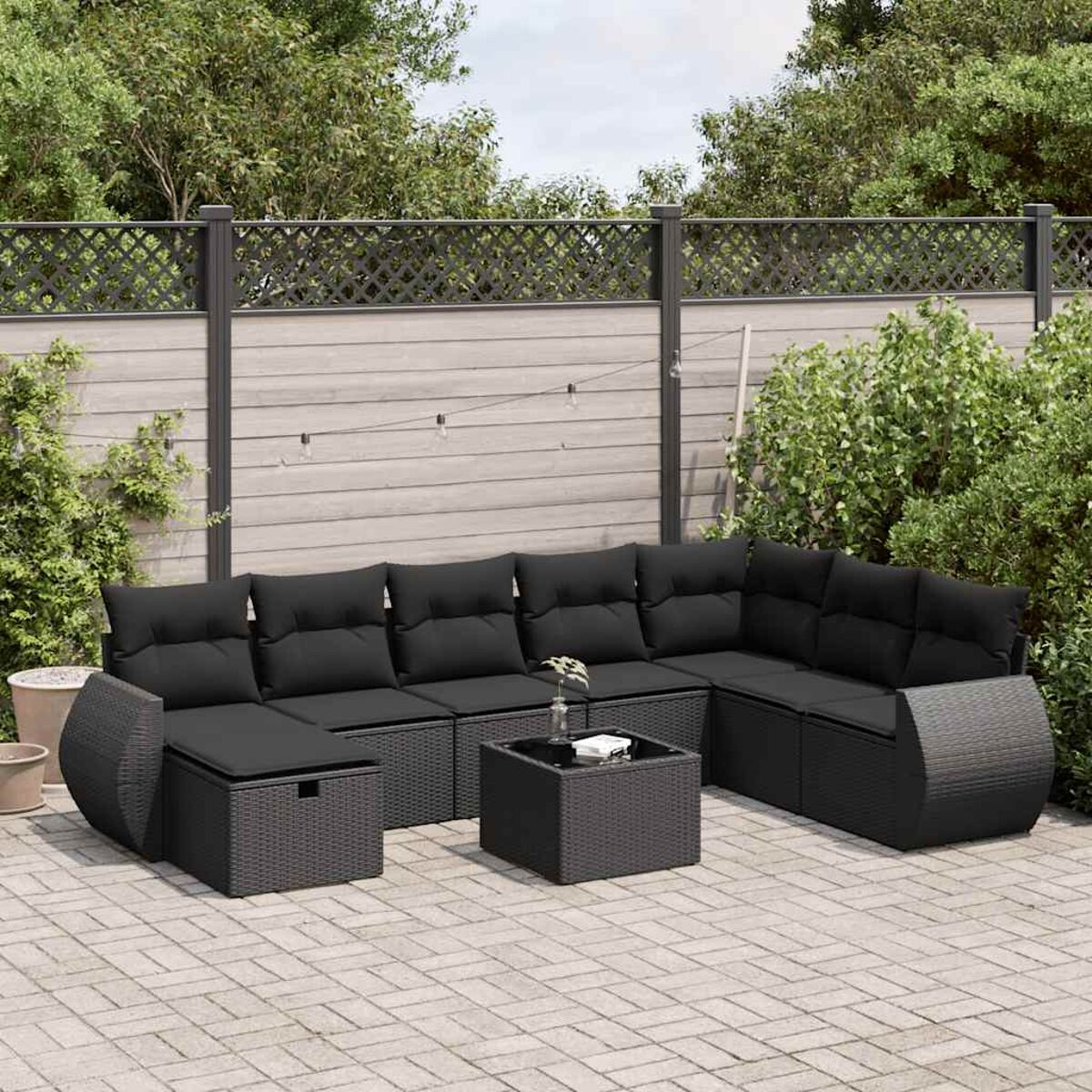 Schwarzes Outdoor-Sofaset aus Korbgeflecht mit einem Tisch.