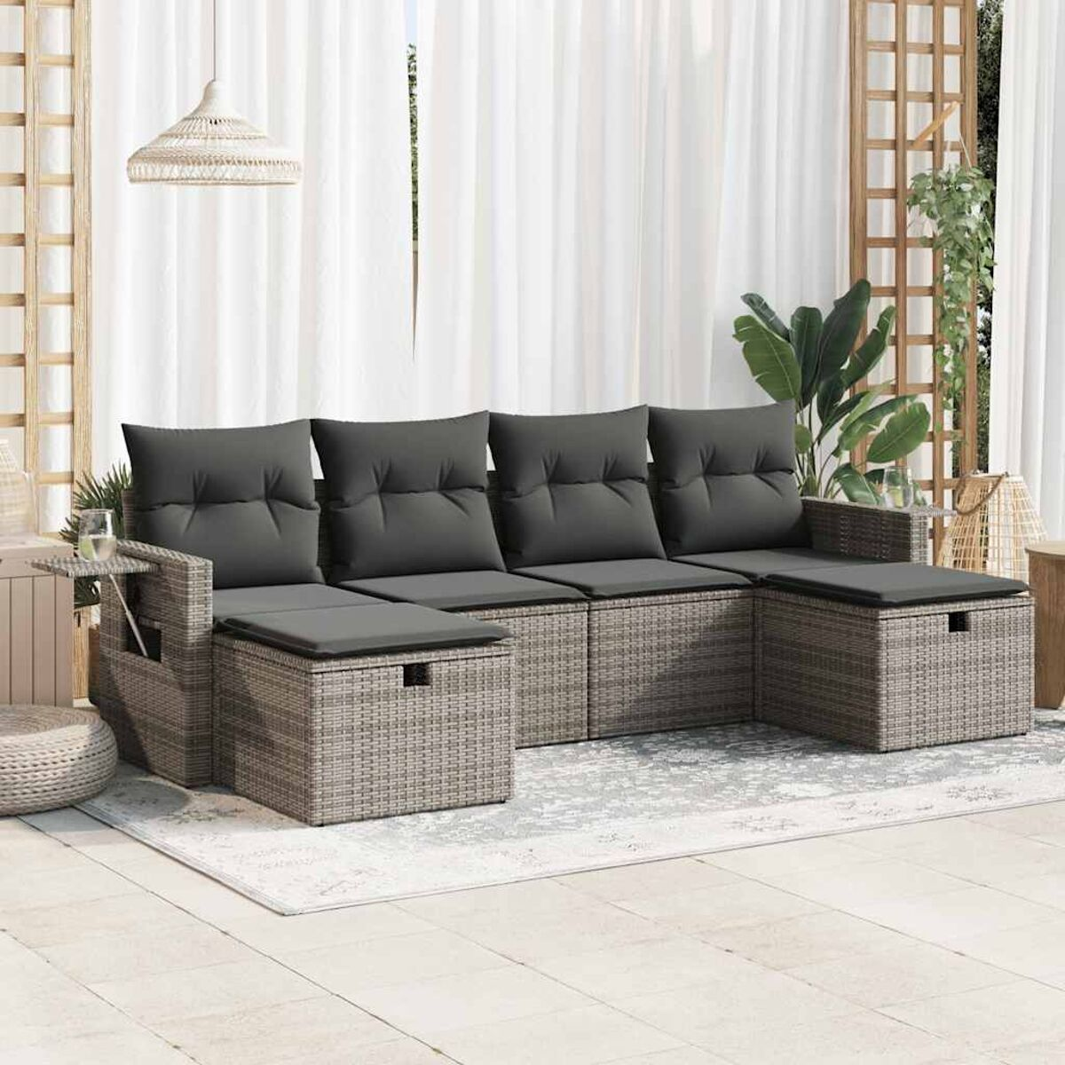 Graues Outdoor-Ecksofa mit Tisch auf einer Terrasse. Hintergrund: weiße Vorhänge und Pflanzen.