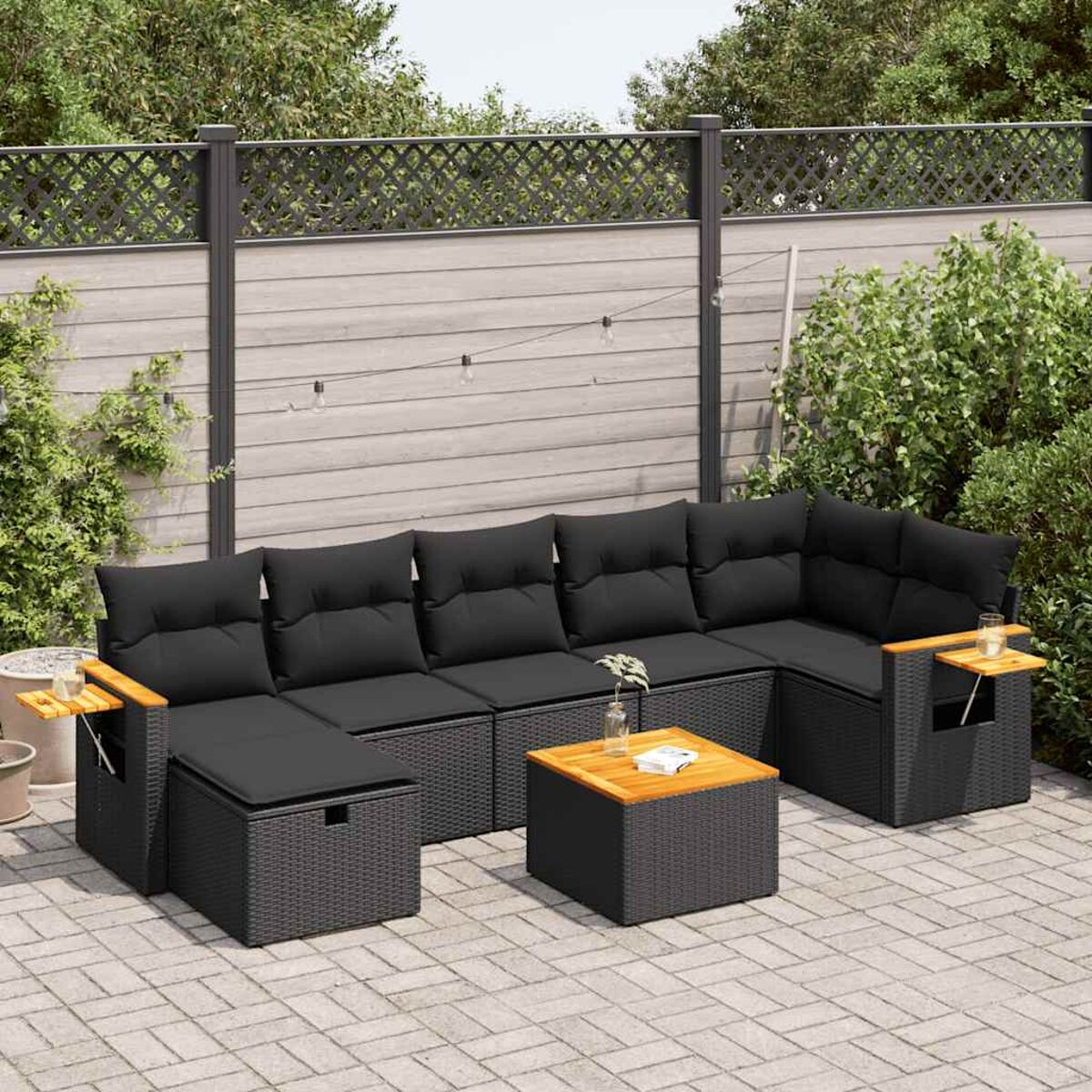 Schwarzes Outdoor-Ecksofa aus Korbgeflecht mit Beistelltischen.