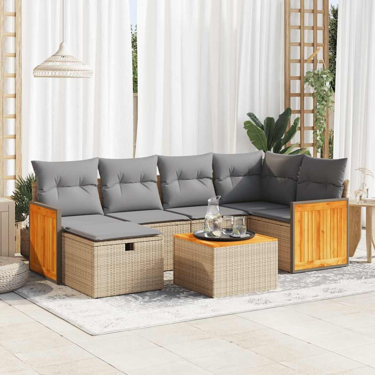 Set divani in rattan da esterno con dettagli in legno e cuscini grigi. Include un tavolino.