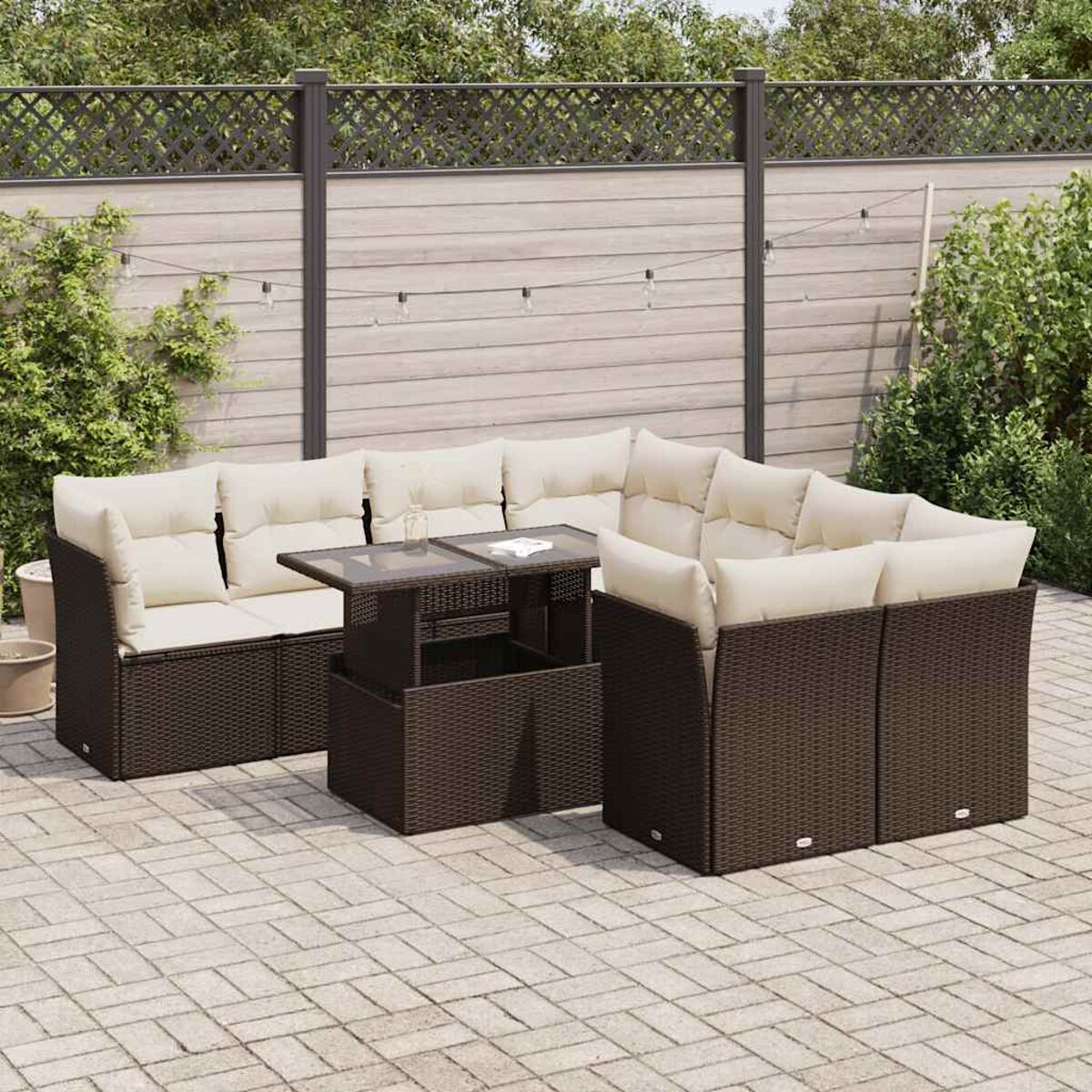 Ein Terrassenset mit braunem Korbgeflecht und cremefarbenen Kissen. Auf einer Ziegelterrasse.