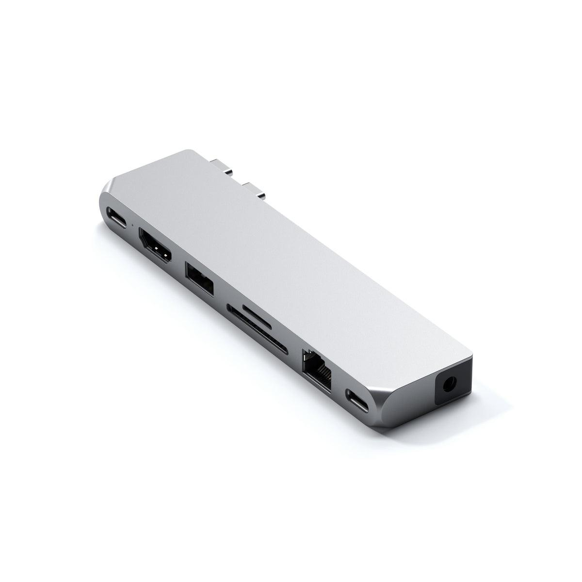 Silberner USB-C-Hub mit mehreren Anschlüssen. HDMI, USB, SD-Karte, Ethernet. Weißer Hintergrund.