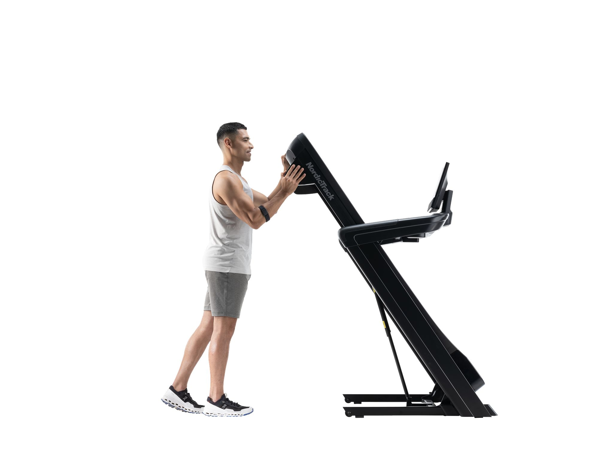Mann im Tanktop benutzt ein Laufband, im Fitnessstudio. Konzentriert auf Training und Fitness.