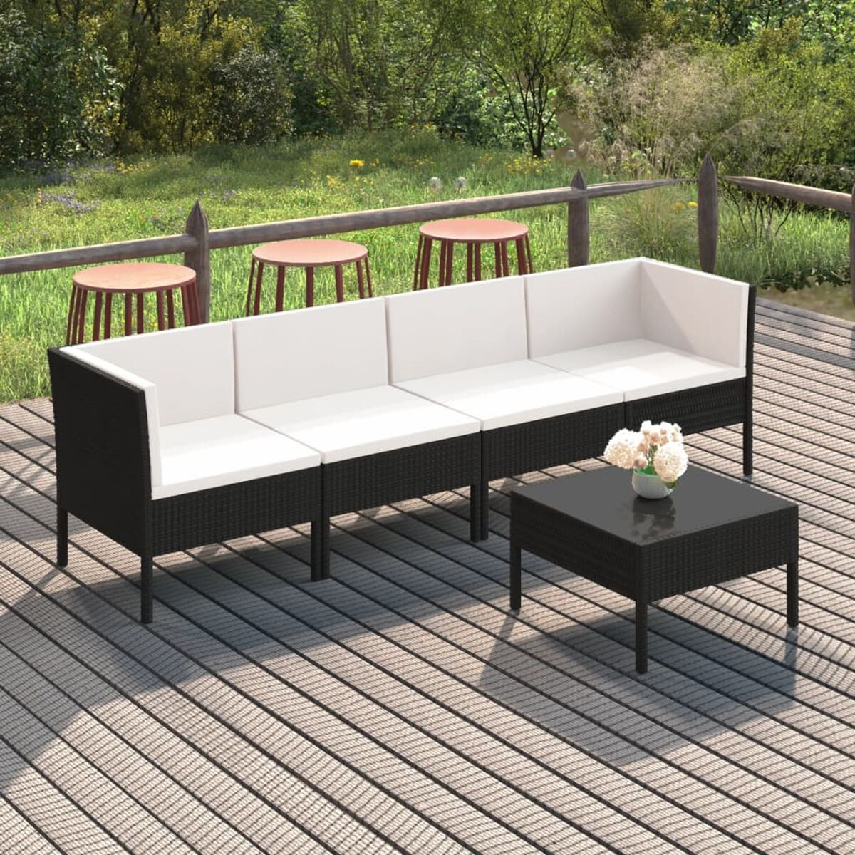 Schwarzes Outdoor-Korbsessel-Set mit weißen Kissen und einem schwarzen Couchtisch auf einem Deck.