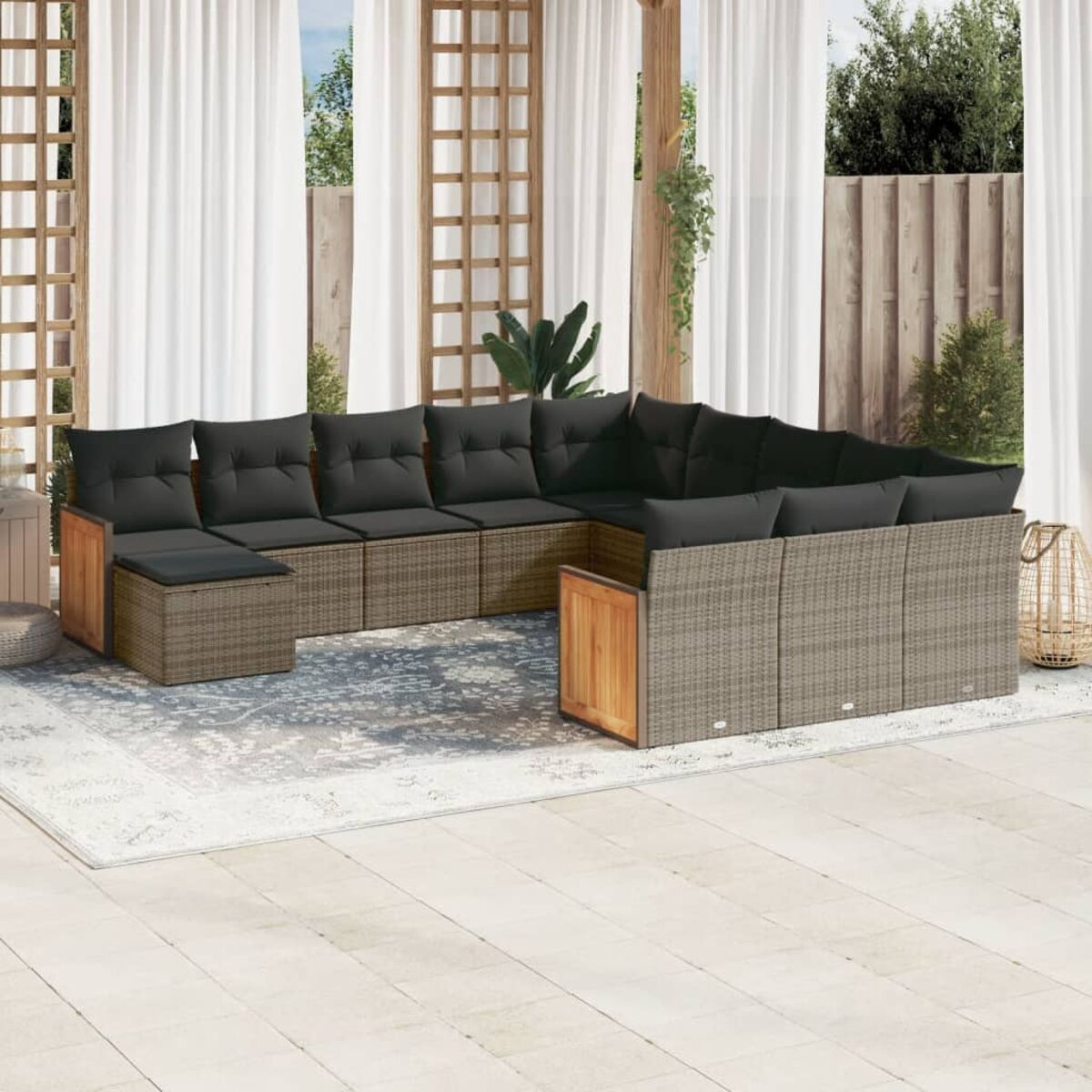 Outdoor-Wickersofa-Set mit grauen Kissen und Holzakzenten. Ein Teppich und Vorhänge sind zu sehen.