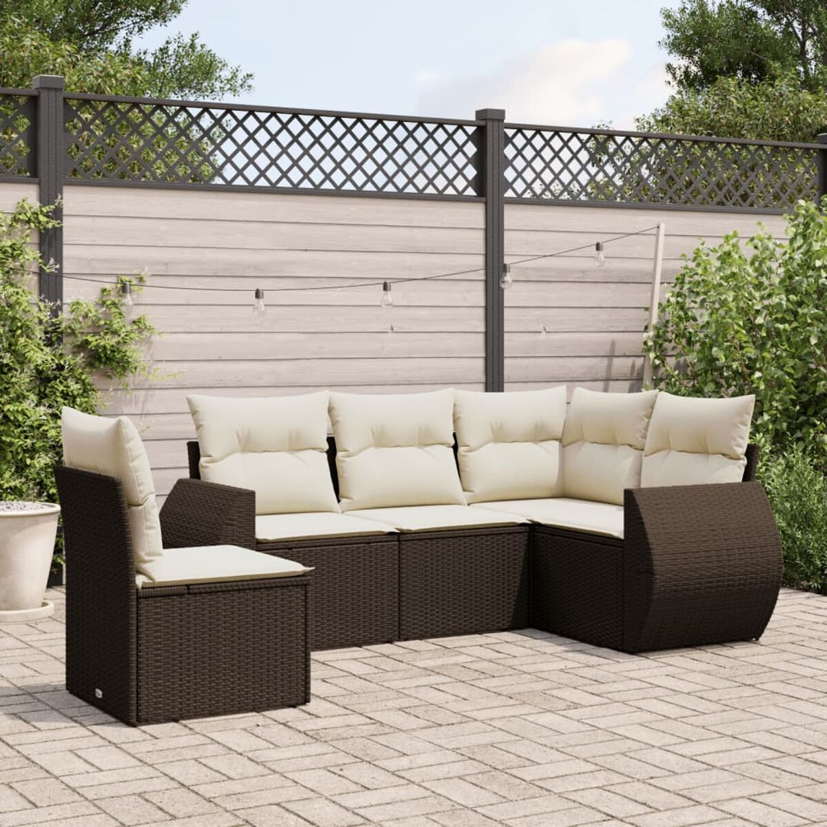 Set di sedute per esterni in vimini marrone con cuscini beige, sedia e tavolo.