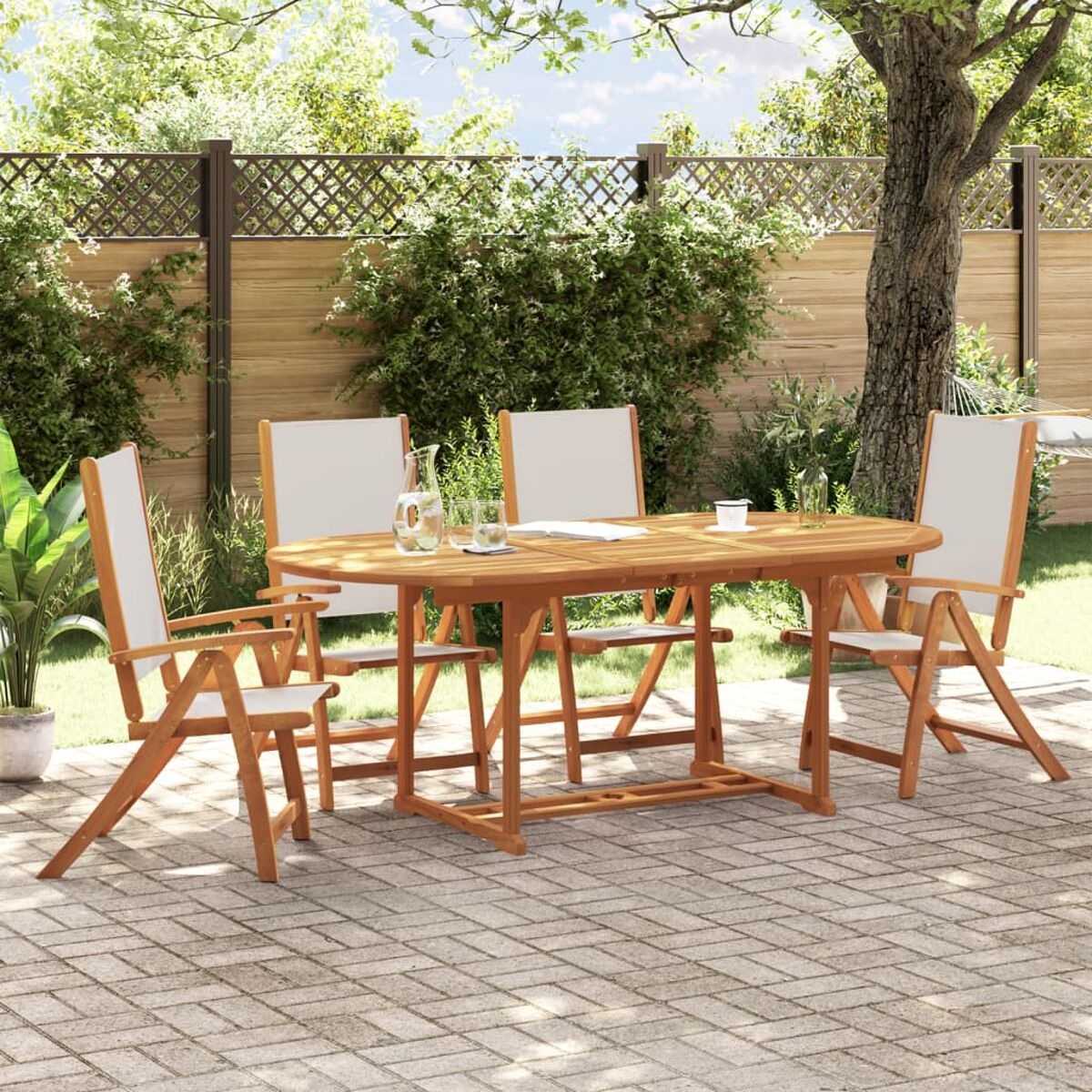 Un set da pranzo all'aperto con tavolo in legno, sedie e bicchieri. Su un patio pavimentato, con alberi.