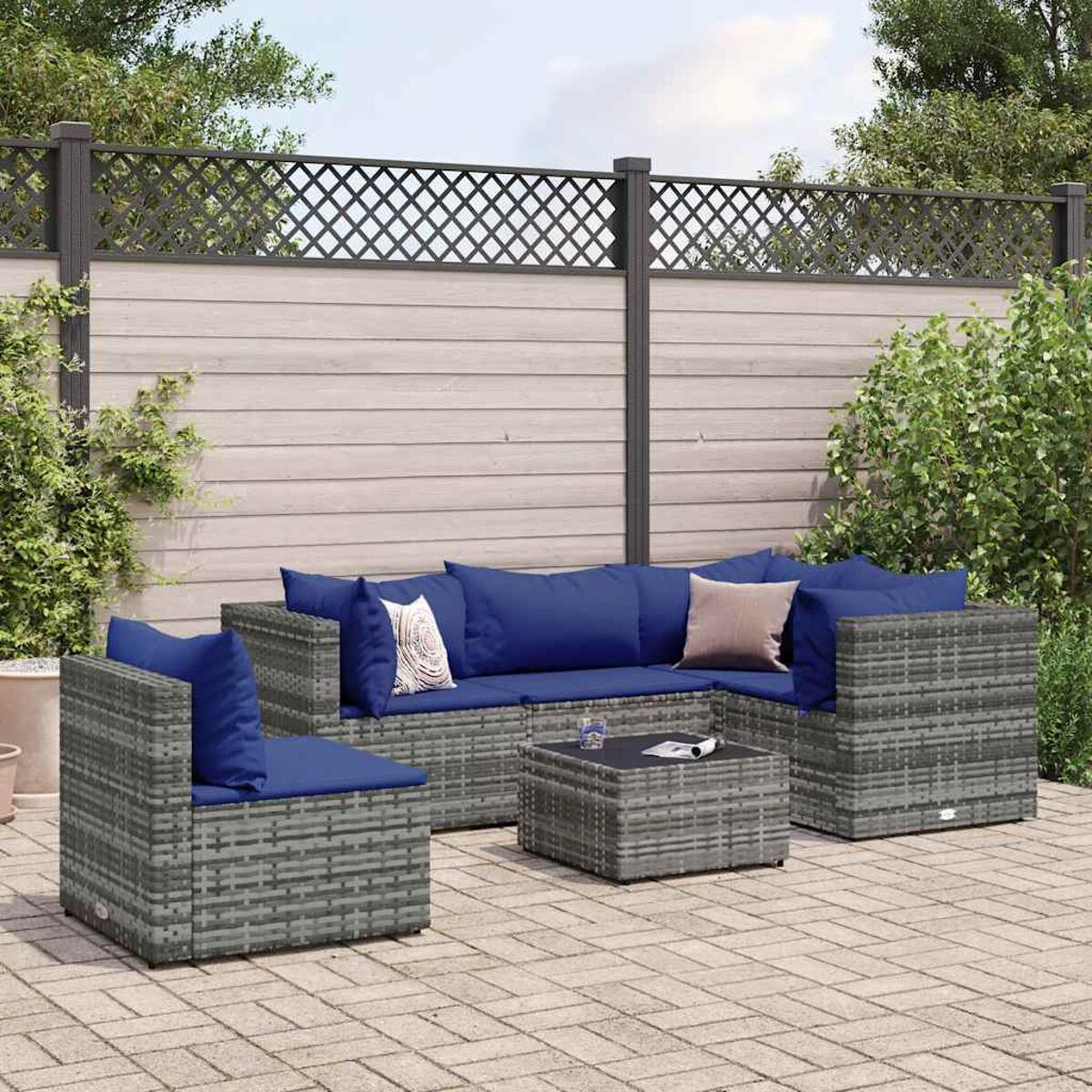 Set da patio. Mobili in vimini grigi con cuscini blu e un tavolo.