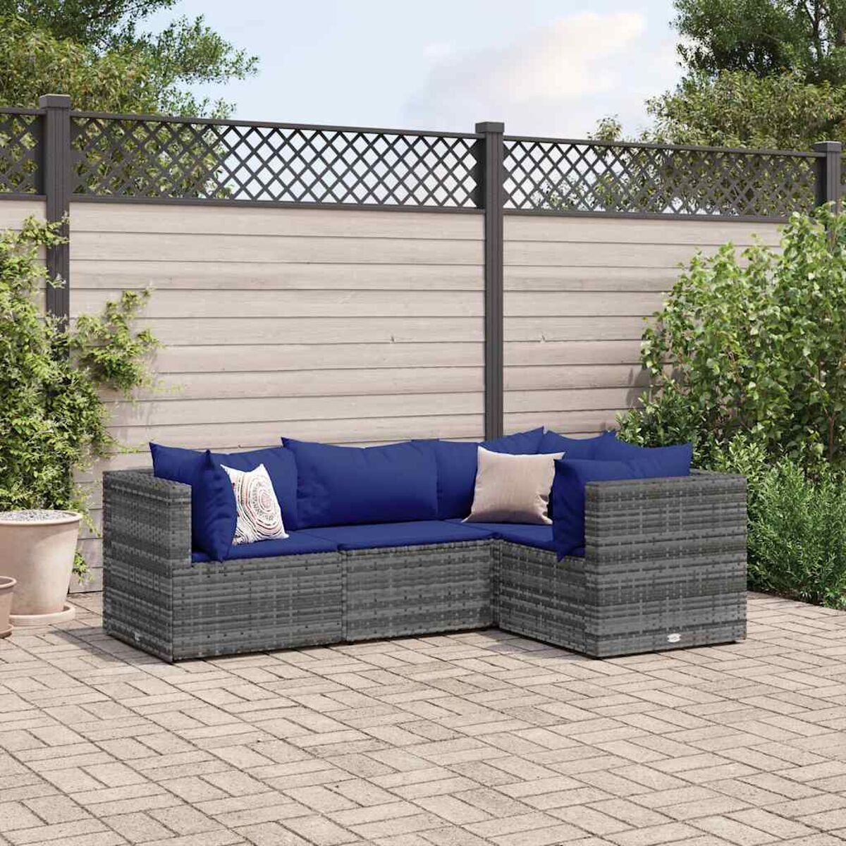 Ein Outdoor-Sofaset mit grauen Webmöbeln und blauen Kissen.