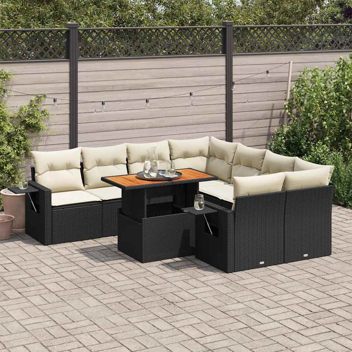 Outdoor-Sofa-Set aus schwarzem Korbgeflecht mit Kissen, Tisch und Getränken.