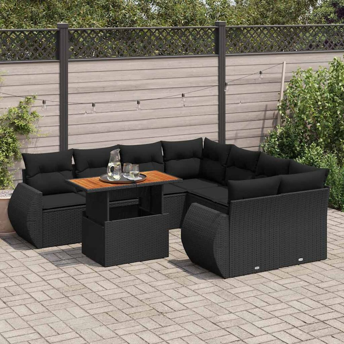 Set da patio esterno nero con divano, sedie e tavolo. I cuscini sono neri.