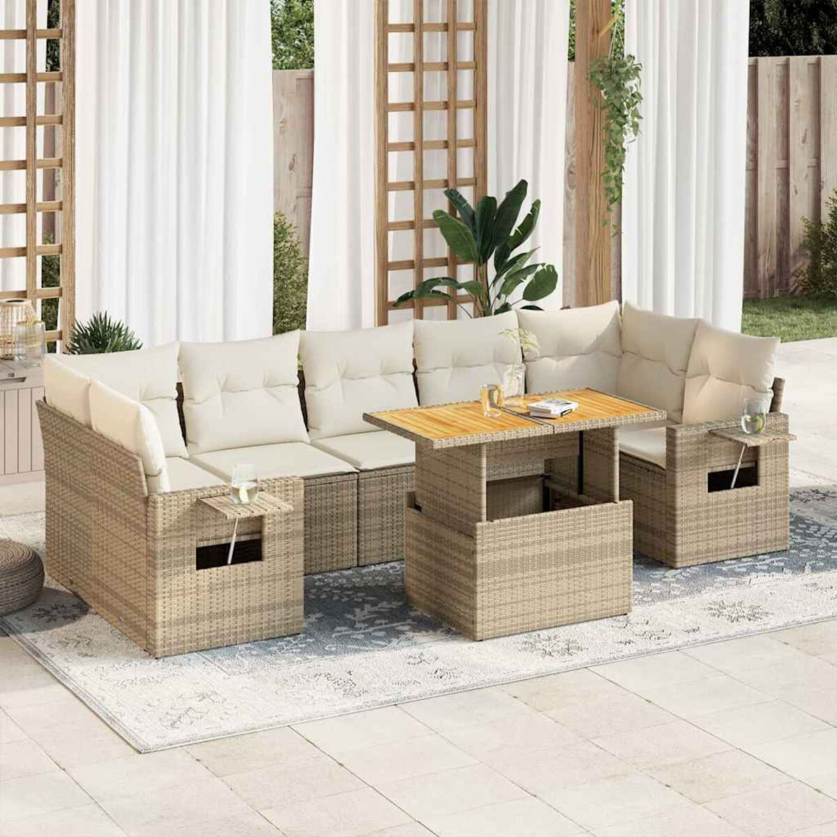 Set da patio all'aperto con divani in vimini, tavolo e cuscini color crema.