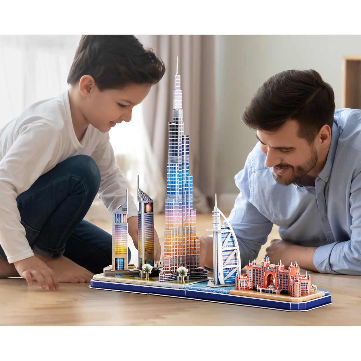 Niño y hombre construyendo juntos un modelo de edificios de Dubái. Edificios coloridos.