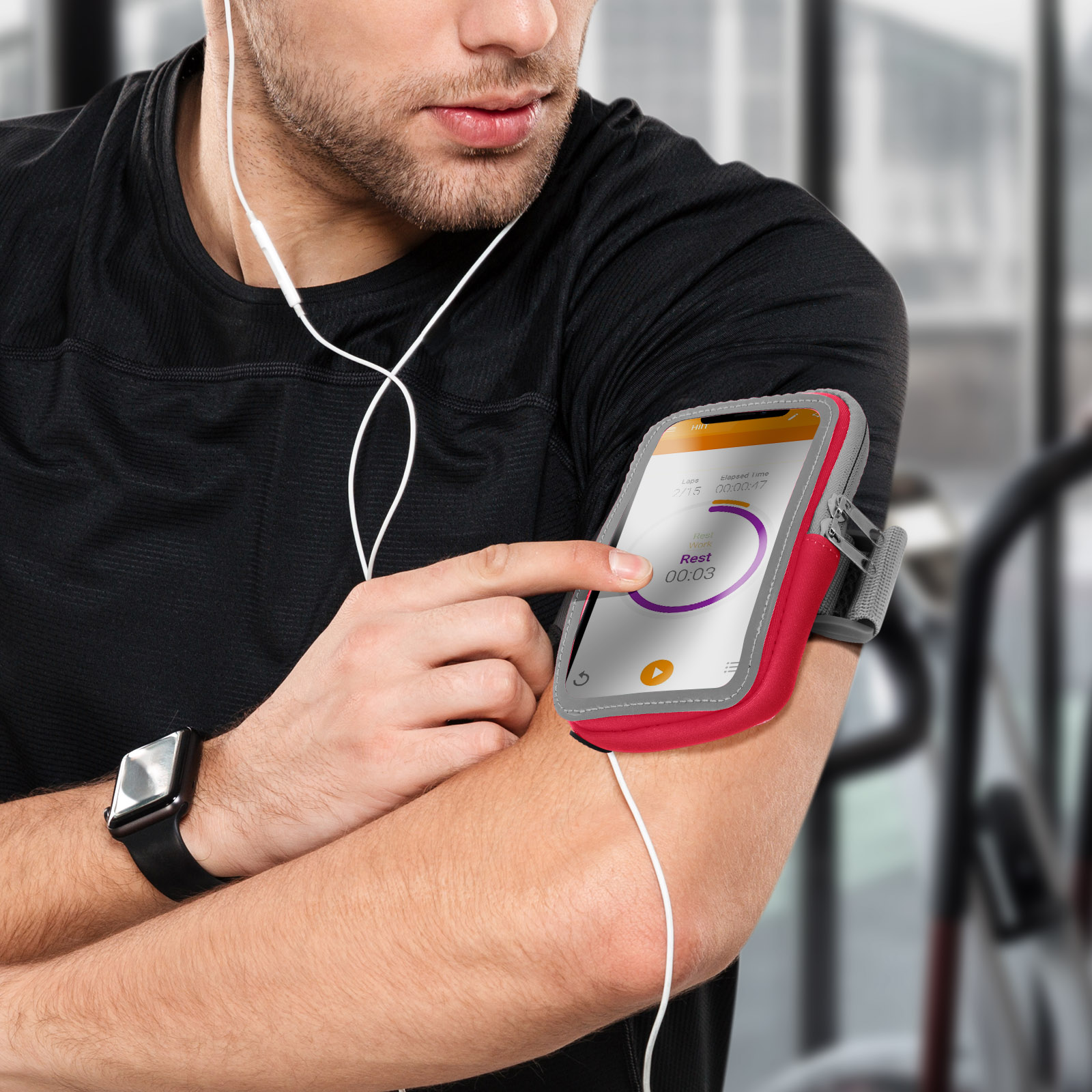 Ein Mann in einem schwarzen Hemd und einer Smartwatch benutzt ein Telefon an seinem Arm.