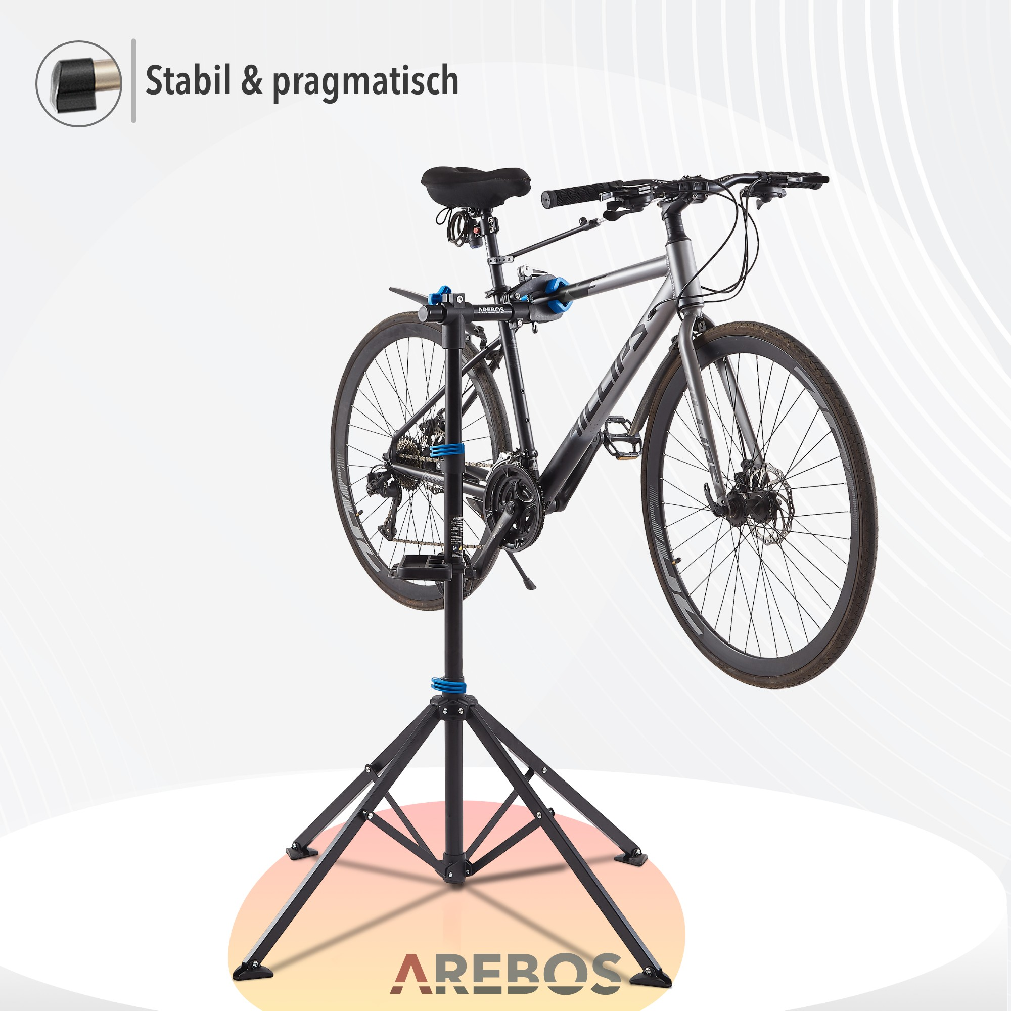Ein graues Fahrrad auf einem schwarz-blauen Reparaturständer montiert. Text 'Stabil & pragmatisch' befindet sich auf dem Bild.