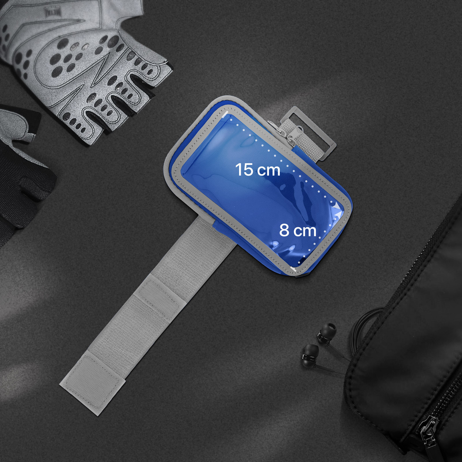 Blauer Telefonhalter mit Abmessungen 15x8 cm auf schwarzer Oberfläche. Handschuhe und Tasche sind sichtbar.