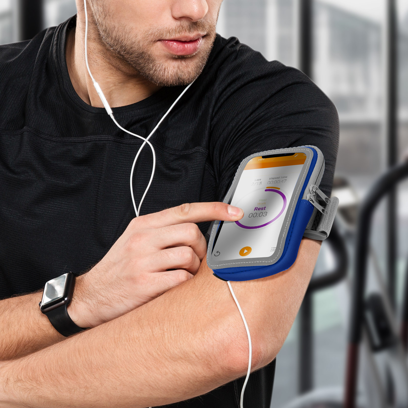 Mann mit schwarzem Hemd und Handy-Armband. Das Telefon zeigt einen Workout-Timer.