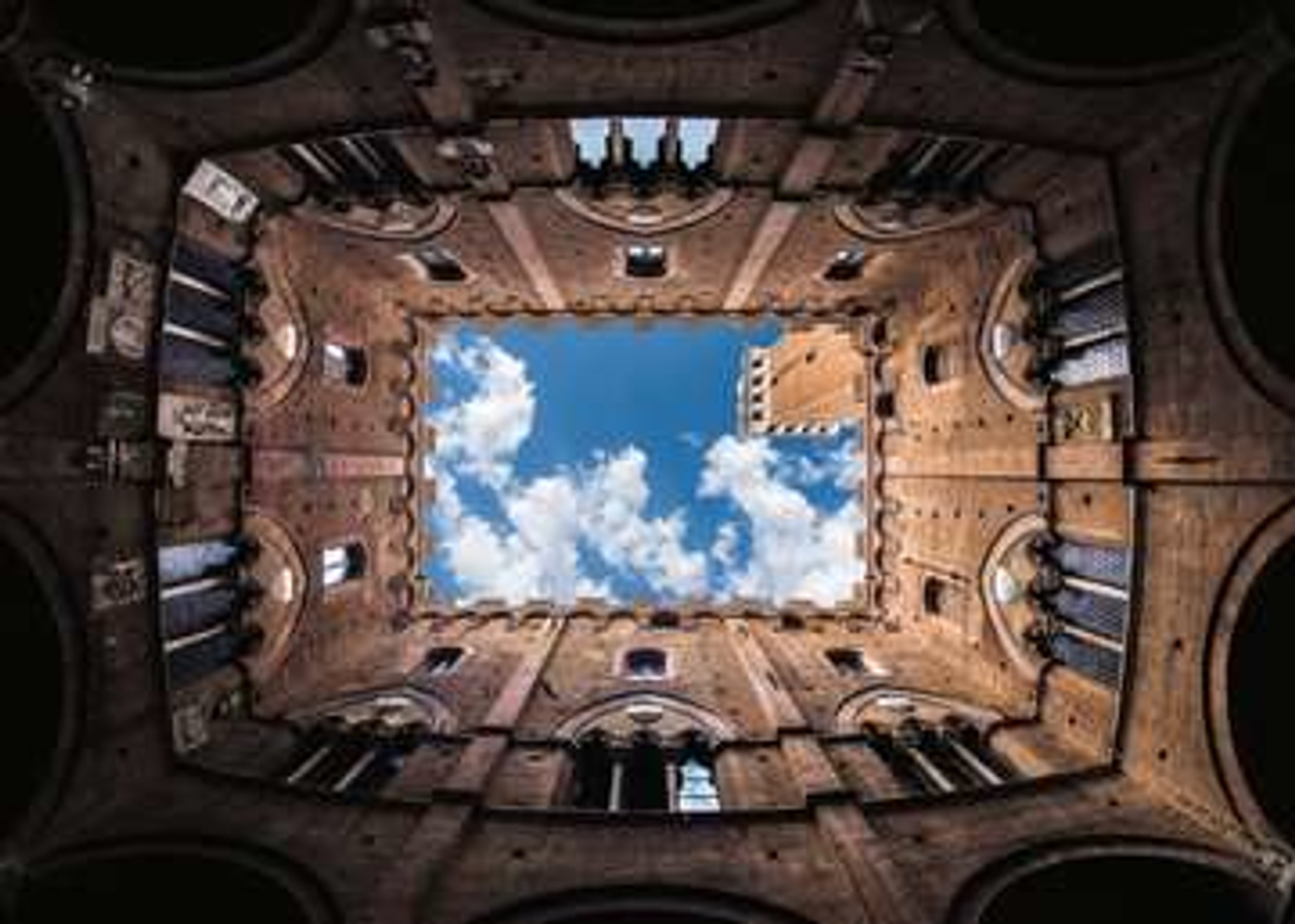 Scatto dal basso verso l'alto di un edificio in mattoni con cielo aperto sopra.