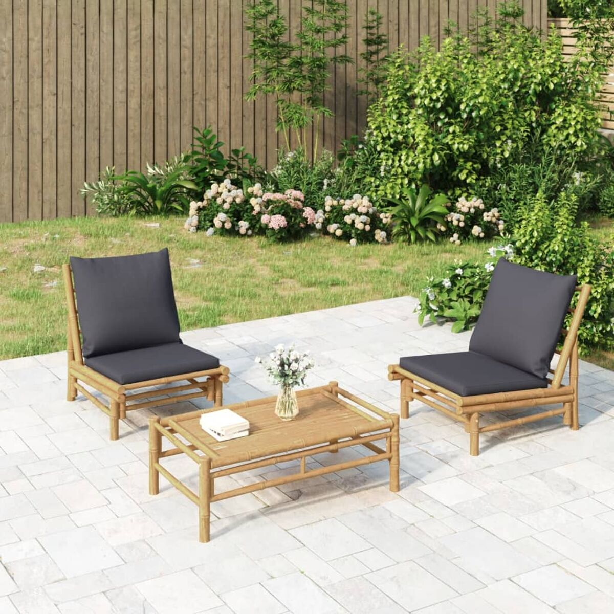 Bambus-Terrassenset für den Außenbereich mit zwei Stühlen, einem kleinen Tisch und einer Blumenvase. Graue Kissen.