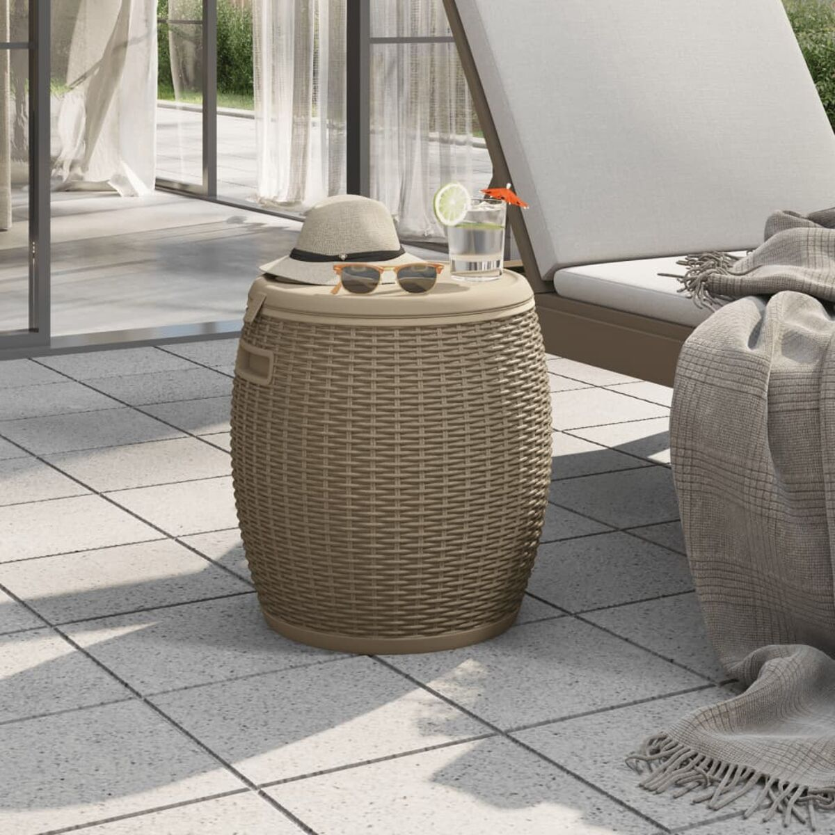 Outdoor-Aufbewahrungsbox mit Hut, Sonnenbrille und Getränk. Rattan-Design. Der Hintergrund ist eine Terrasse.