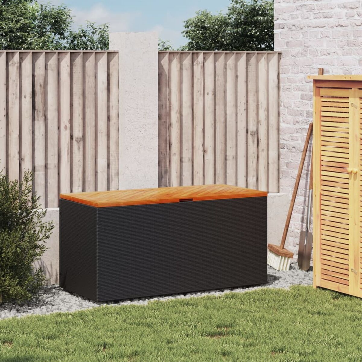 Schwarze Aufbewahrungsbox mit Holzdeckel auf grünem Rasen.