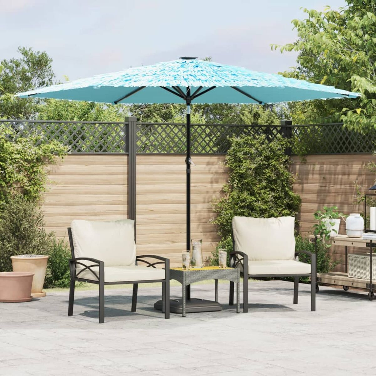 Outdoor-Sitzbereich mit blauem Sonnenschirm, zwei Stühlen und einem kleinen Tisch.