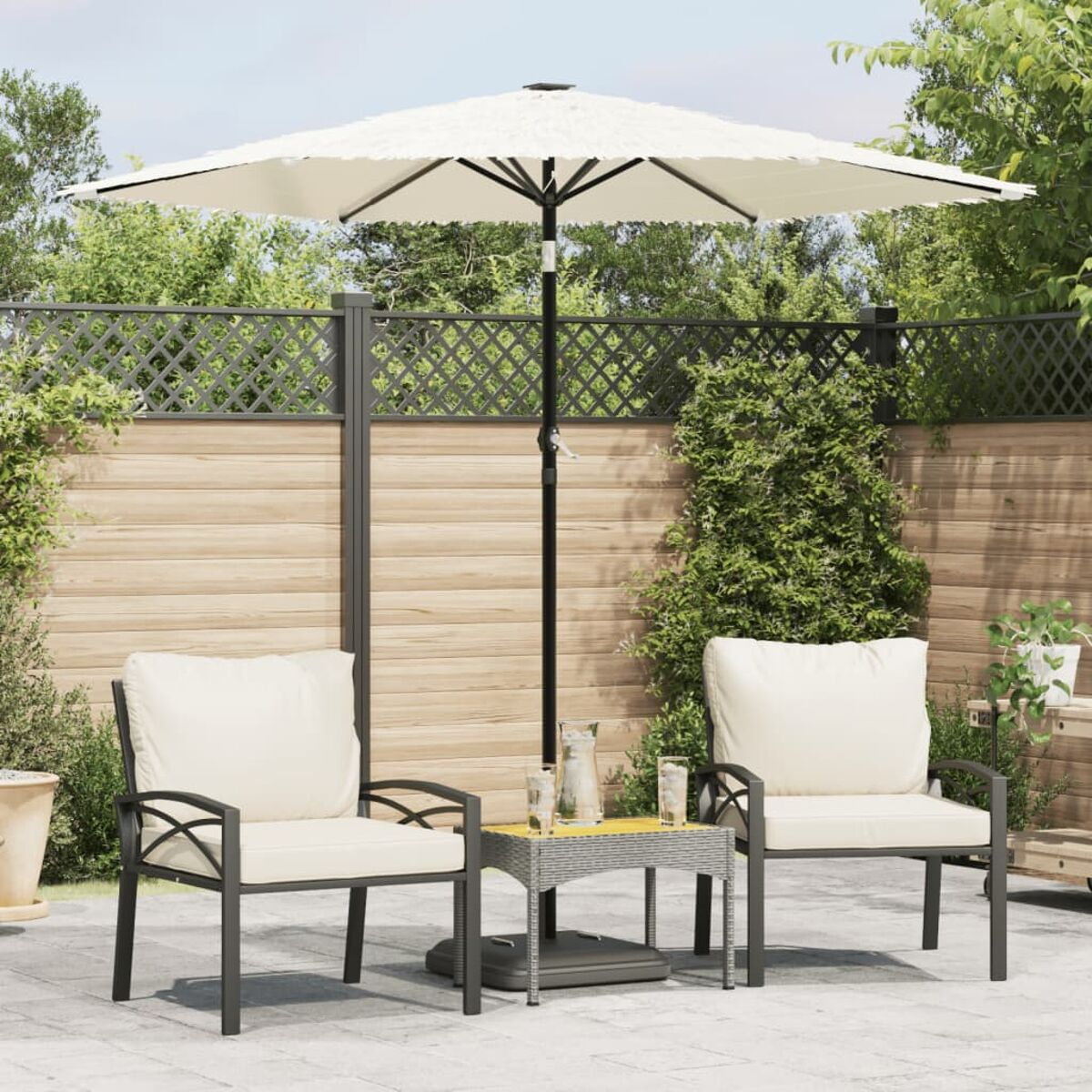 Configurazione del patio all'aperto. Due sedie con cuscini, tavolino, ombrellone e recinzione in legno.