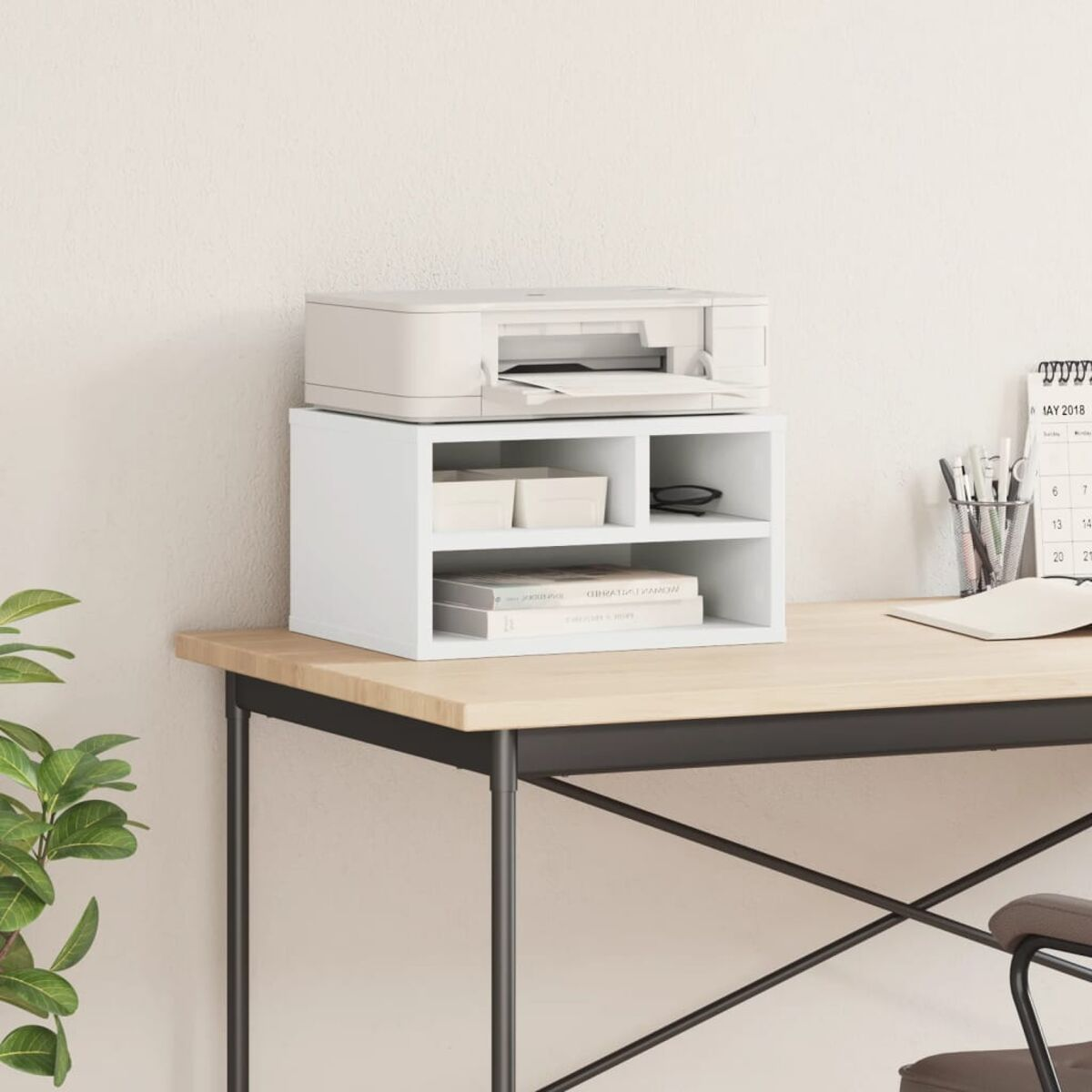 Weißer Drucker auf einem weißen Regal auf einem Holztisch. Der Hintergrund ist eine weiße Wand.