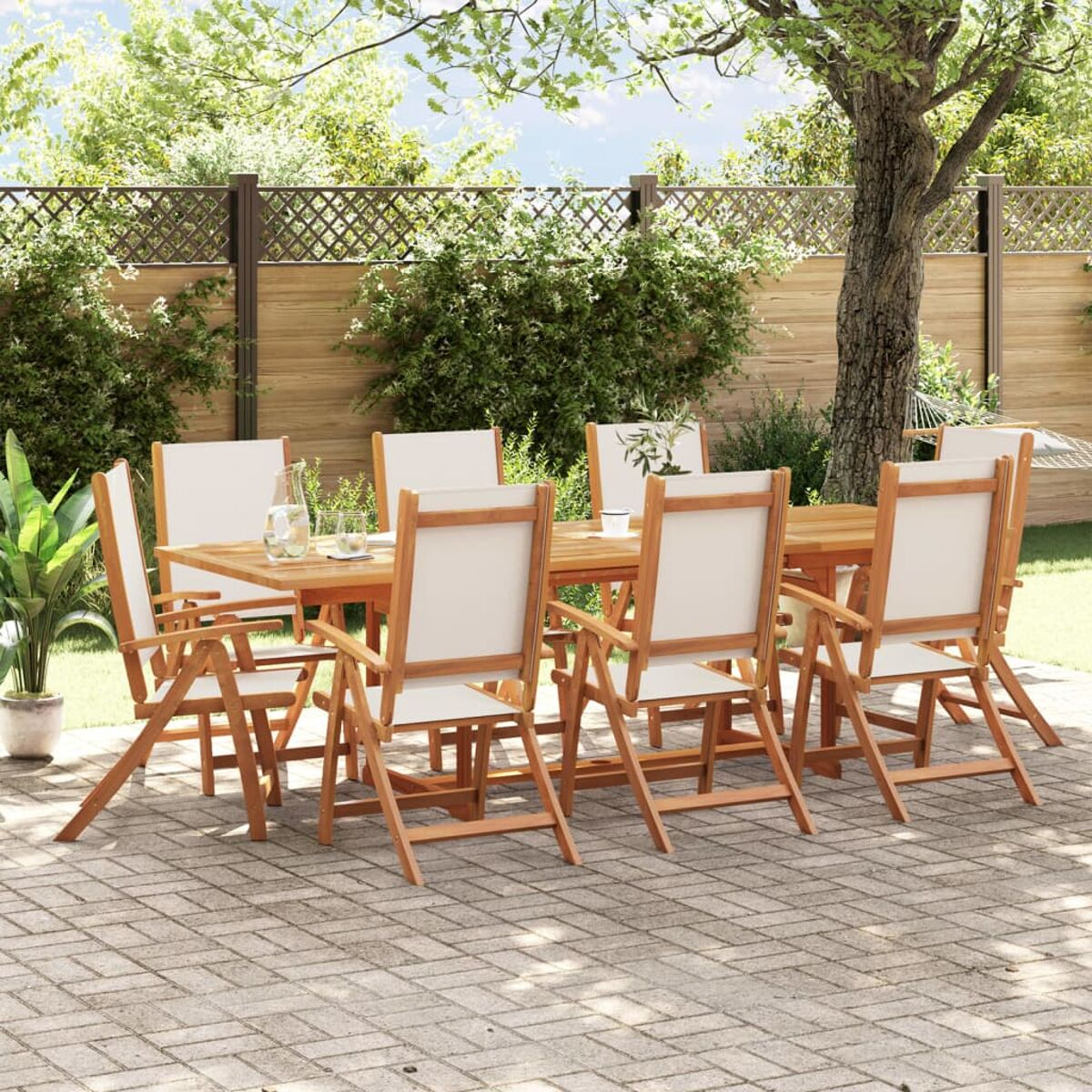 Juego de comedor al aire libre. Mesa y sillas de madera con cojines blancos, jardín.