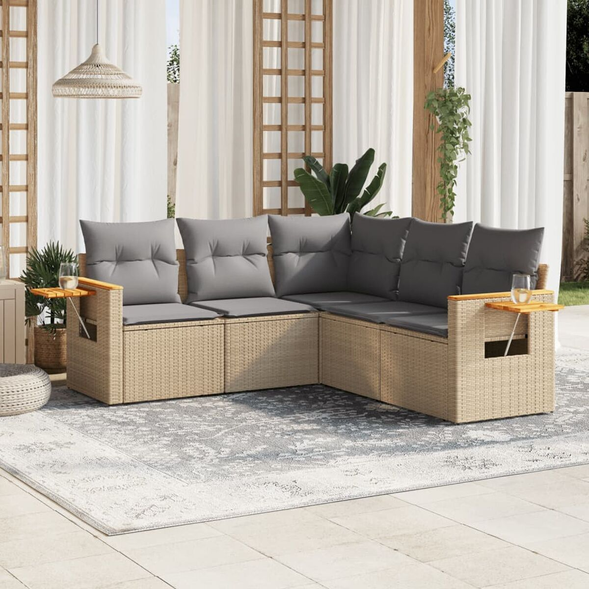 Outdoor-Ecksofa mit grauen Kissen, Beistelltischen und einem gemusterten Teppich. Holzakzente sind sichtbar.