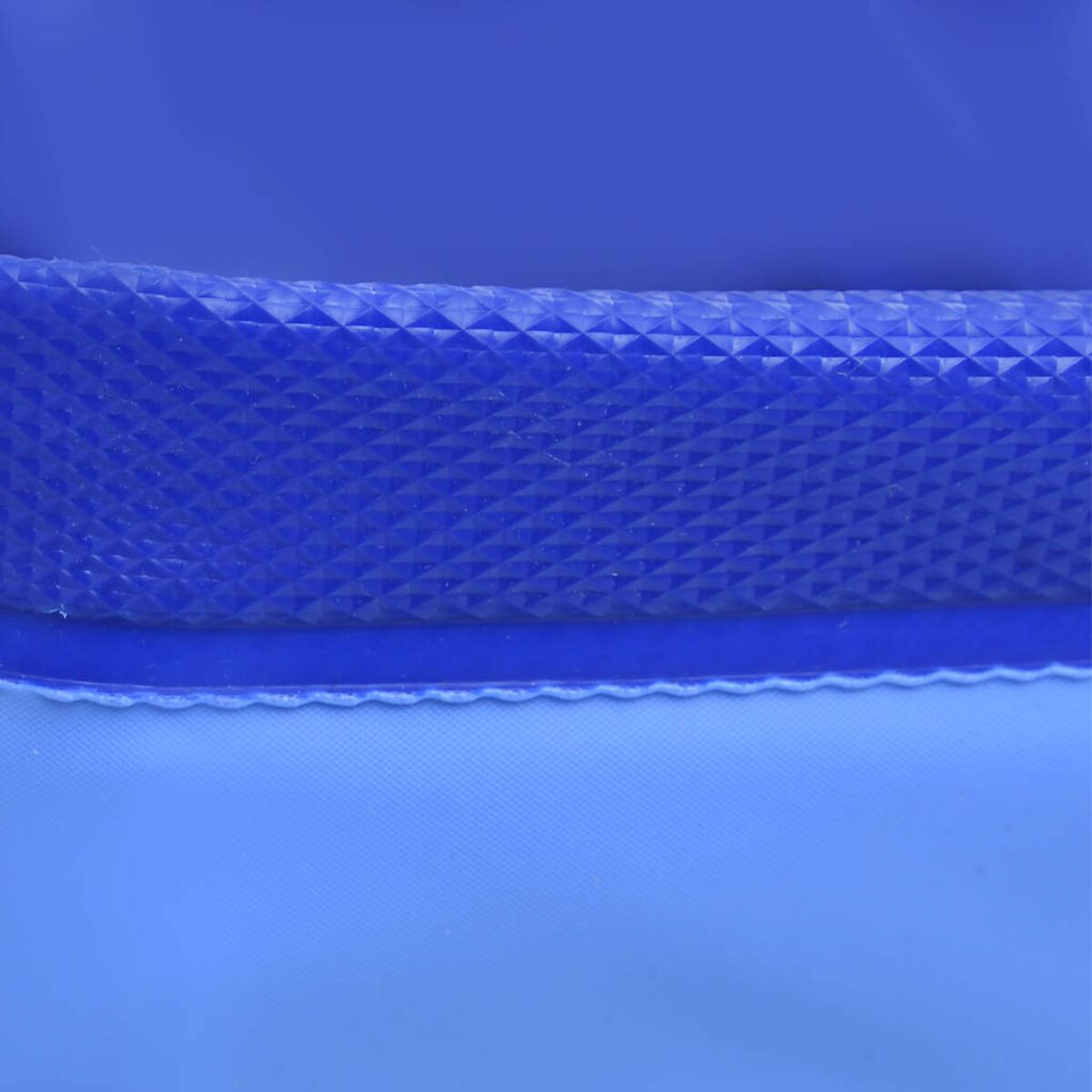 Nahaufnahme einer blauen Kunststoffoberfläche. Sie hat ein strukturiertes, rautenförmiges Muster oben.
