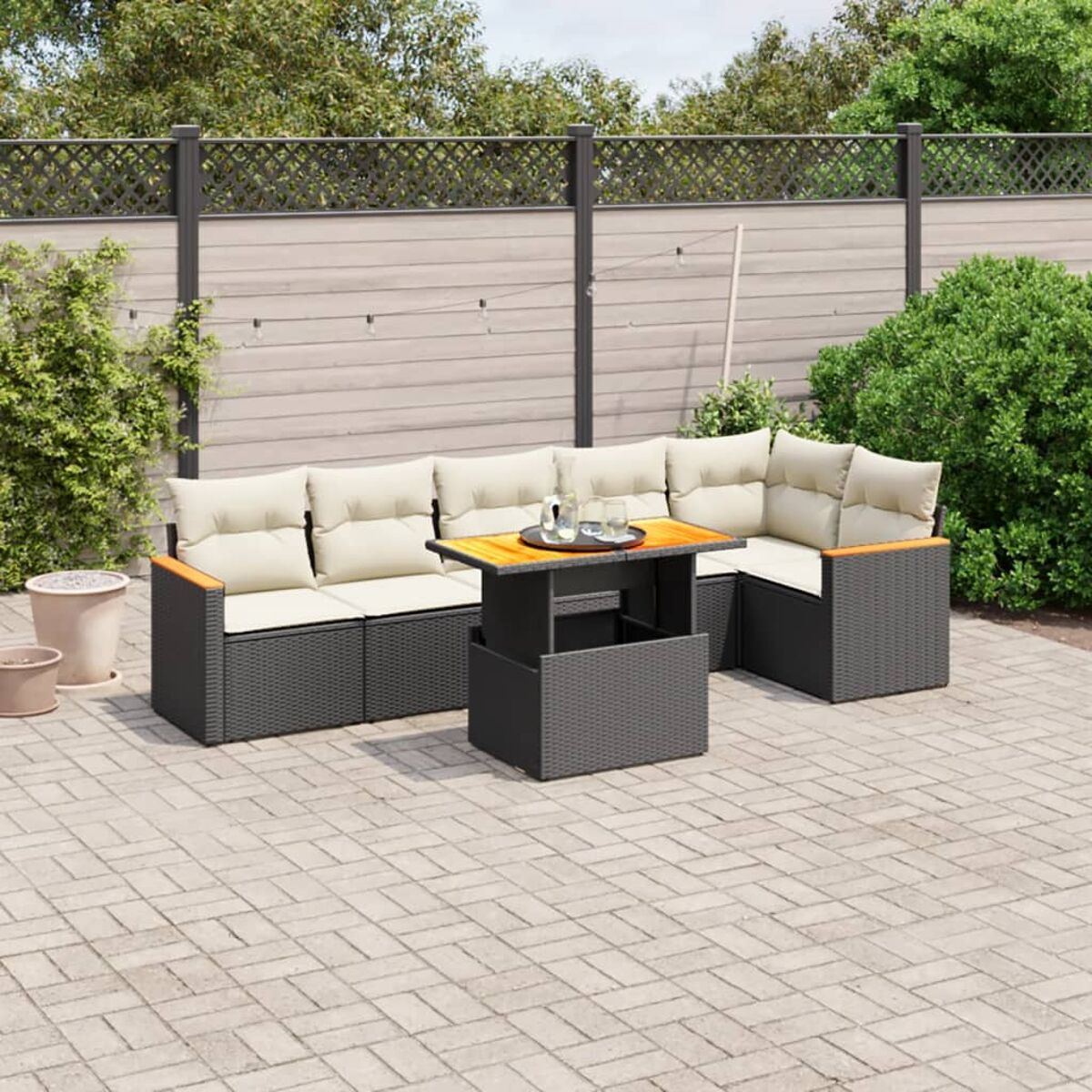 Ecksofa für den Außenbereich mit beigen Kissen, schwarzem Rattan und kleinem Tisch.