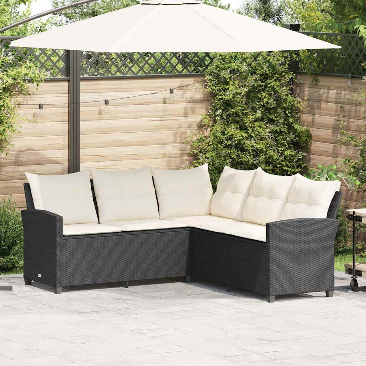 Divano a L da esterno con cuscini bianchi e ombrellone. Ambiente giardino.