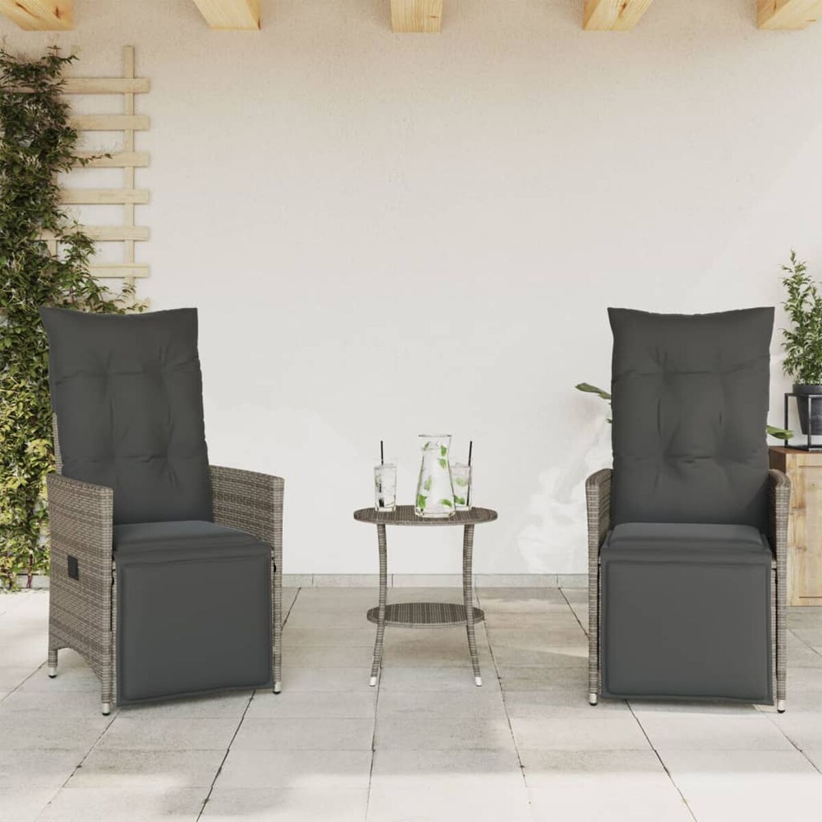 Zwei Rattansessel mit grauen Kissen, ein kleiner Tisch mit Getränken, auf einer Terrasse.