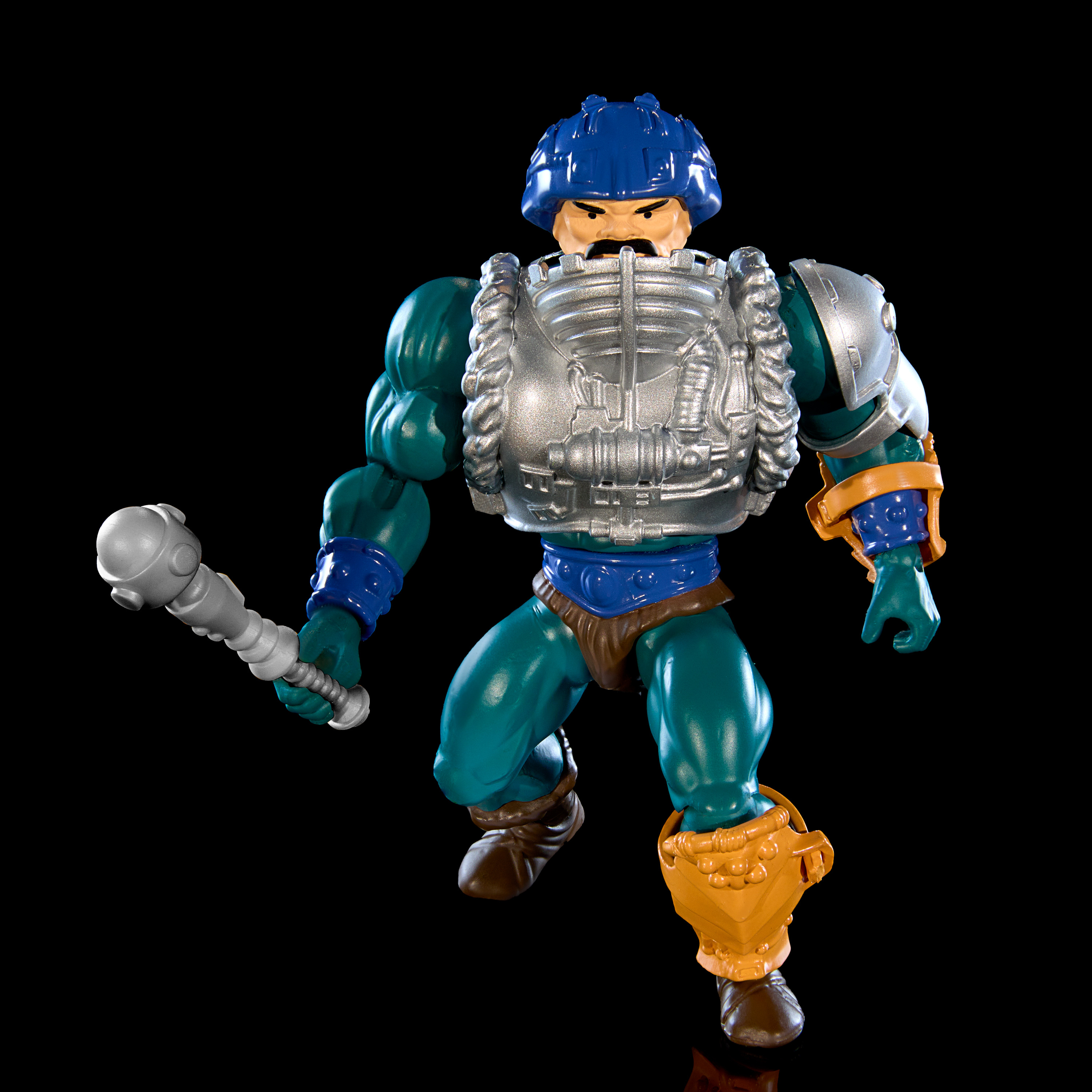 Figura de acción de He-Man con casco azul, armadura y un arma. Fondo negro.