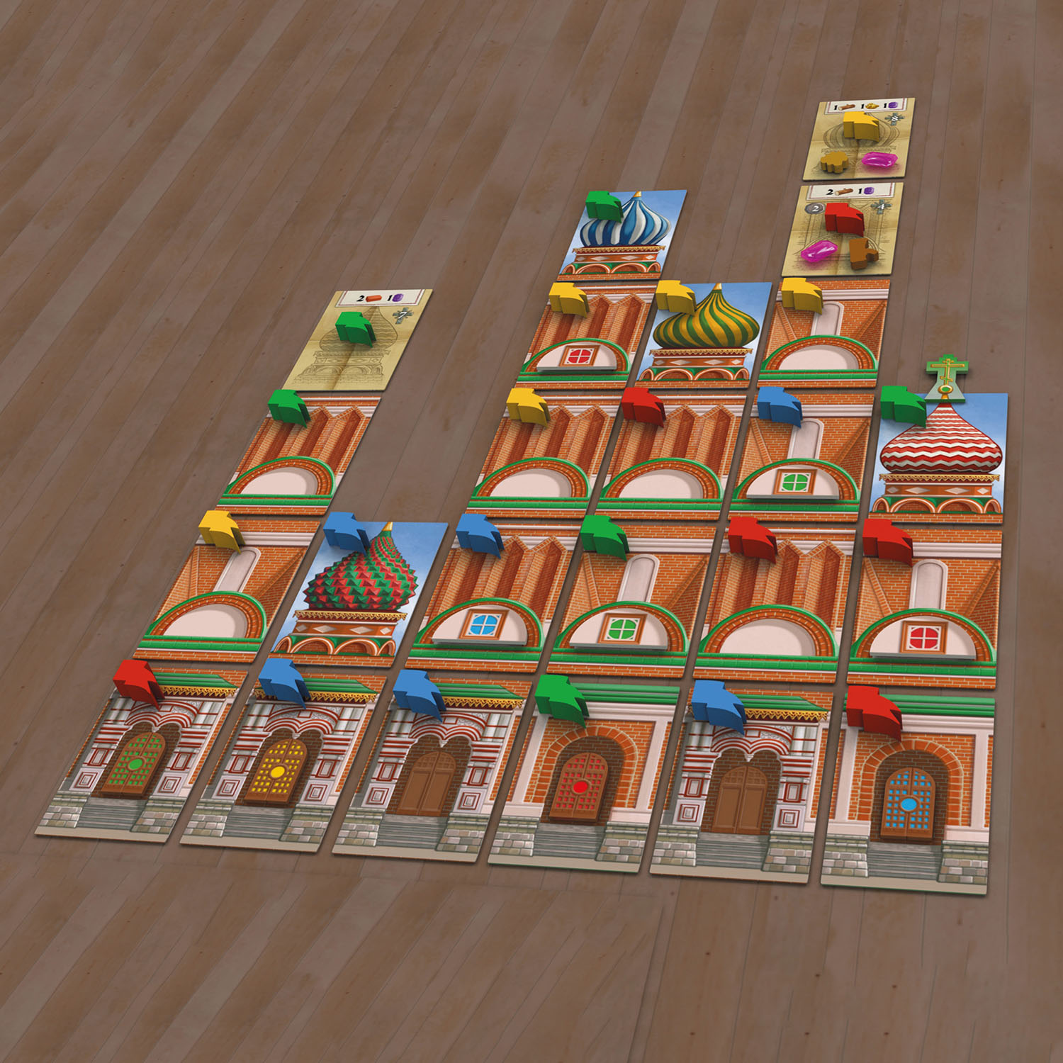 Brettspiel-Layout mit Gebäudekarten und Holzteilen. Das Spiel hat farbenfrohe Elemente.