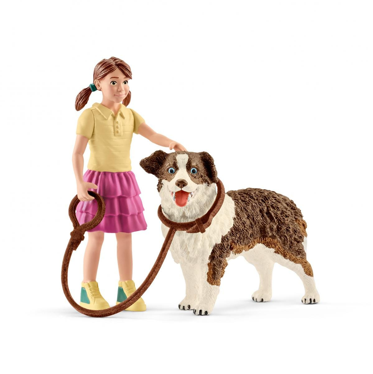 Fille avec un chien, tous deux marron et blanc. La fille tient une laisse.