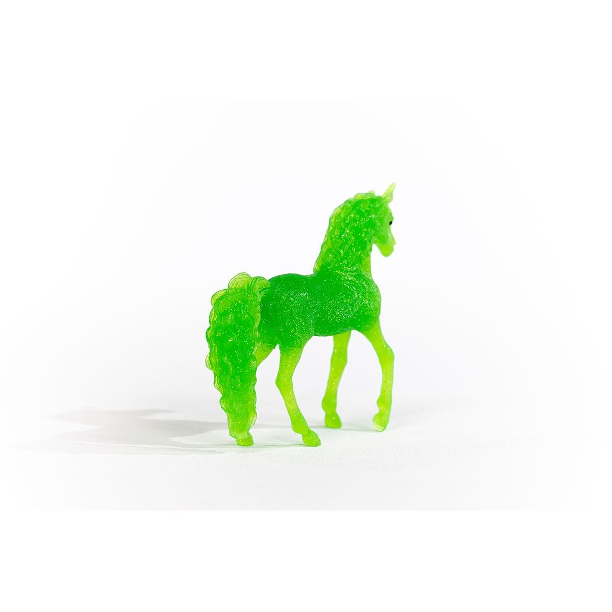 Eine grüne Pferdfigur mit detaillierter Mähne und Schweif, auf weißem Hintergrund.