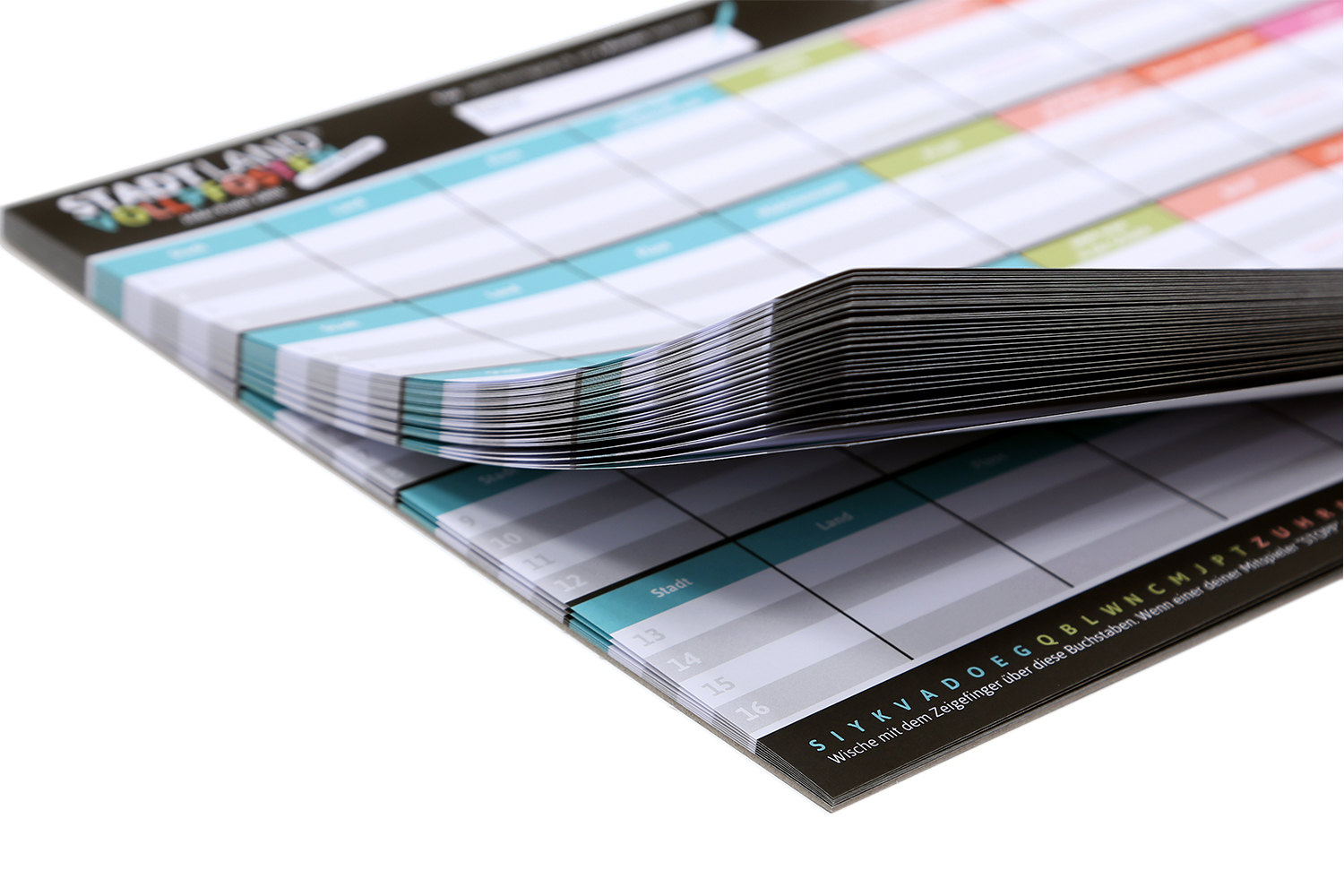 Ein Stapel Papier. Die Papiere haben ein Brettspiel-Layout mit Wörtern und Tabellen. Das Spiel ist Stadt Land Vollpfosten.