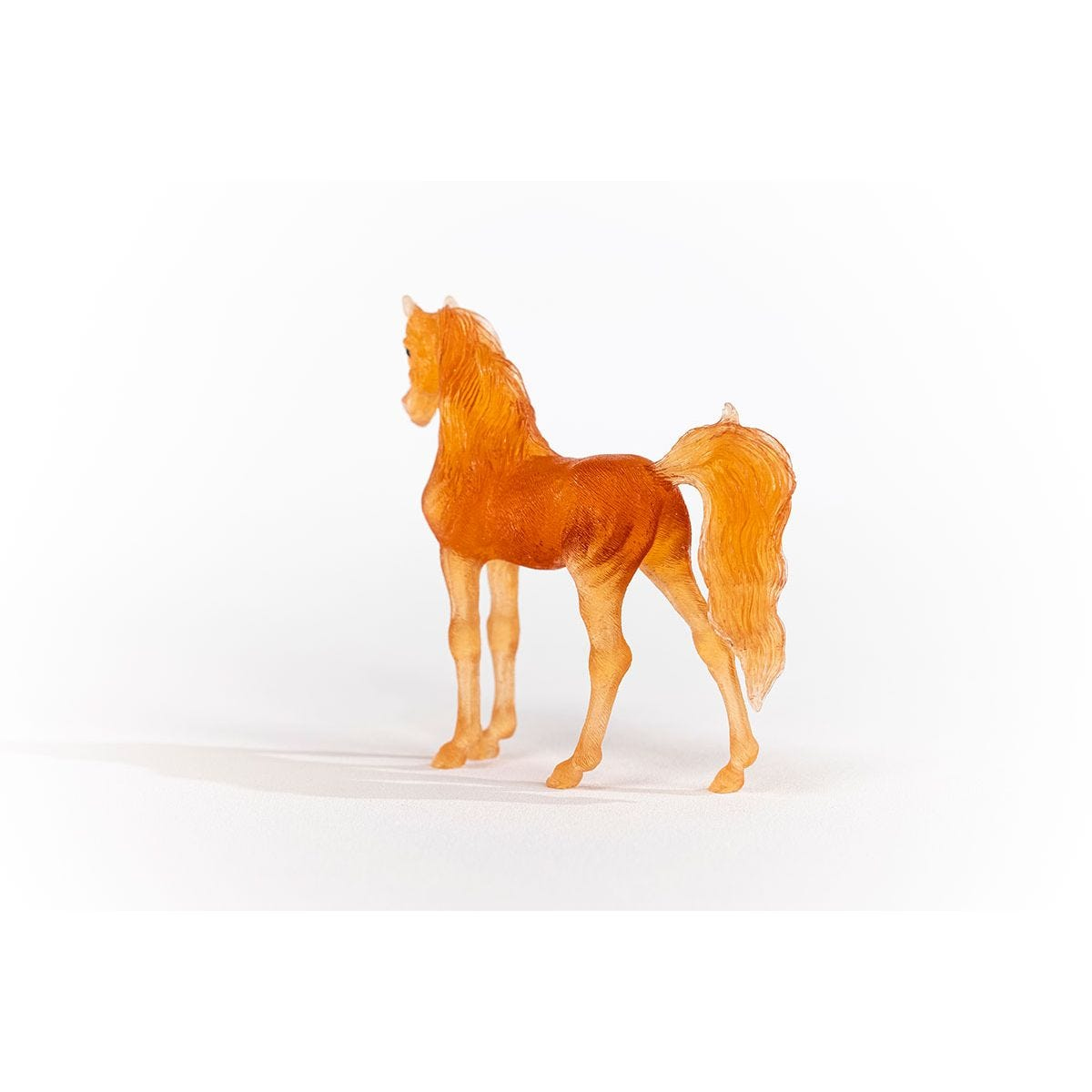 Orangefarbene Pferd-Figur auf weißem Untergrund, Seitenansicht.
