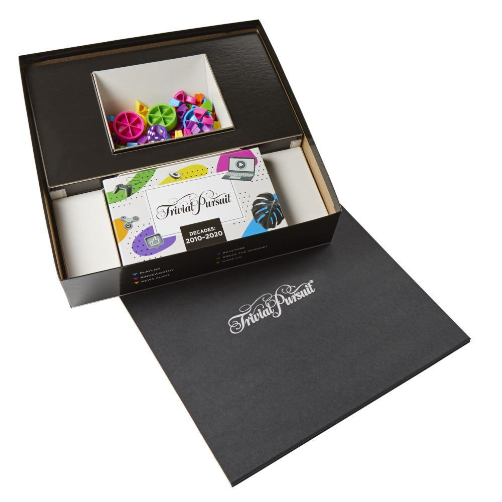 Trivial Pursuit Brettspiel geöffnet, zeigt Spielsteine, Karten und eine schwarze Box.
