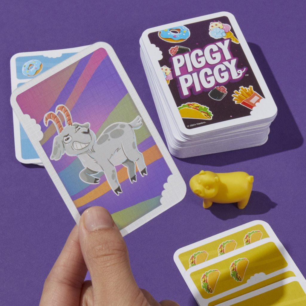 Ein Brettspiel mit Karten und einer gelben Schweinefigur. Das Spiel heißt Piggy Piggy.